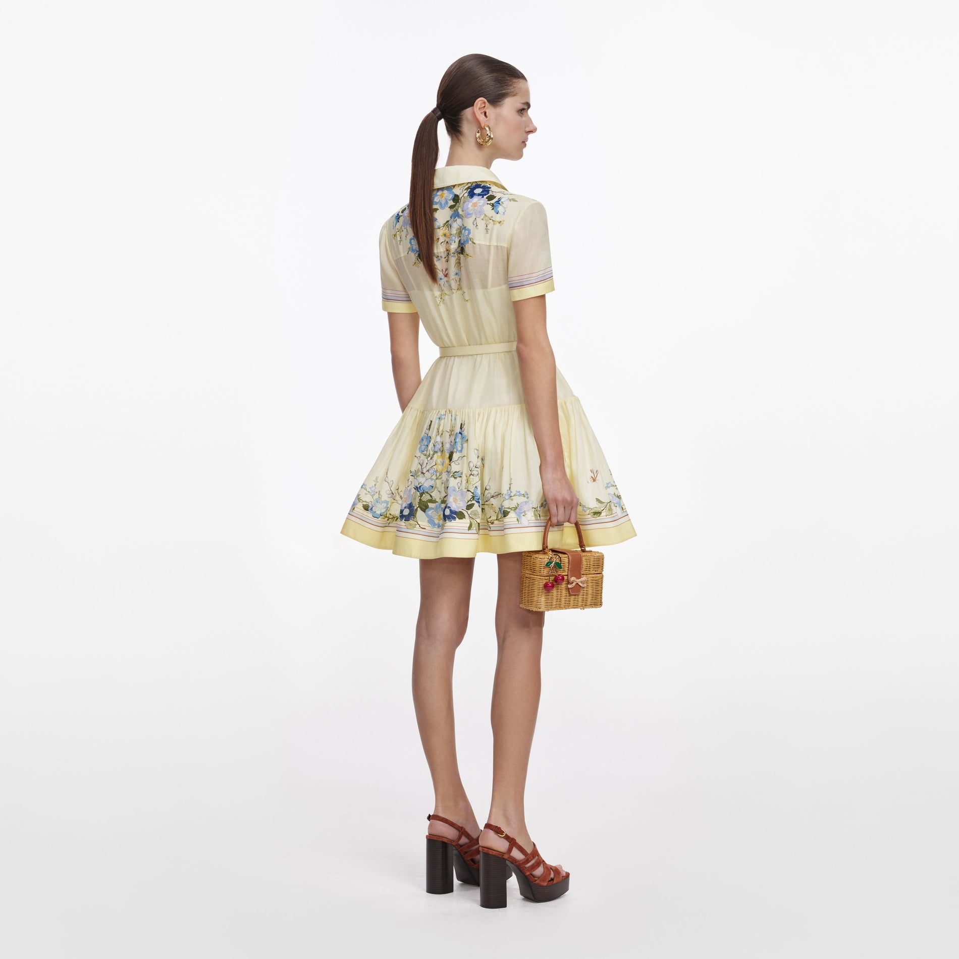 Back view of a woman wearing the Yellow Floral Organza Mini Dress