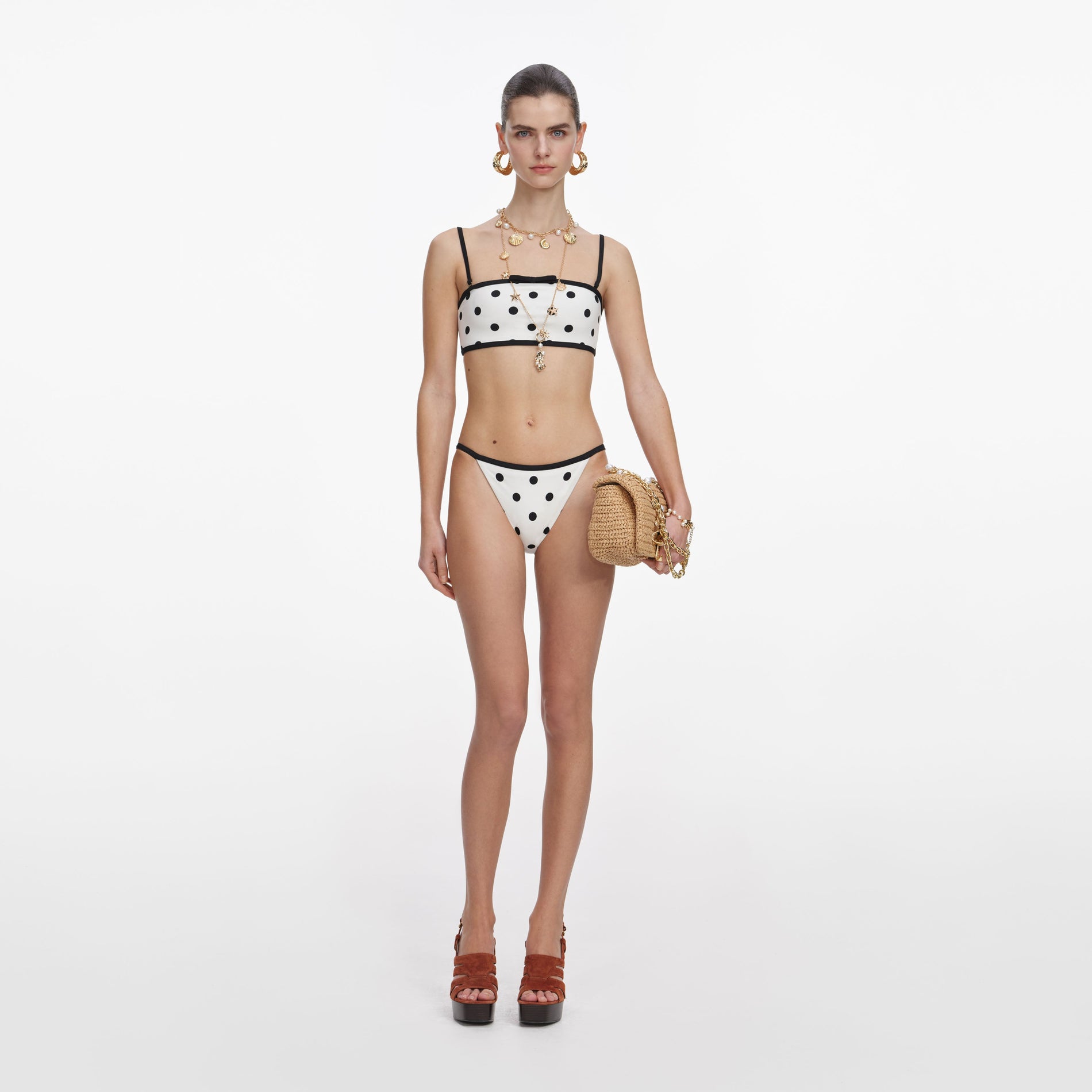 Front view of a woman wearing the White Polka Dot Bikini Bottoms