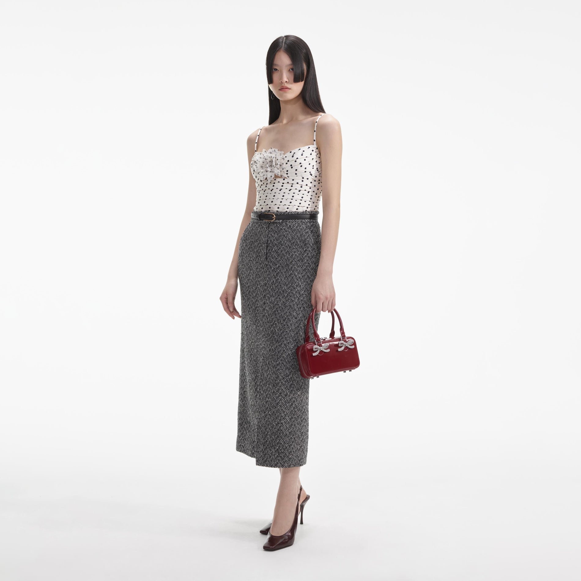 Side view of a woman wearing the Black Herringbone Midi Skirt