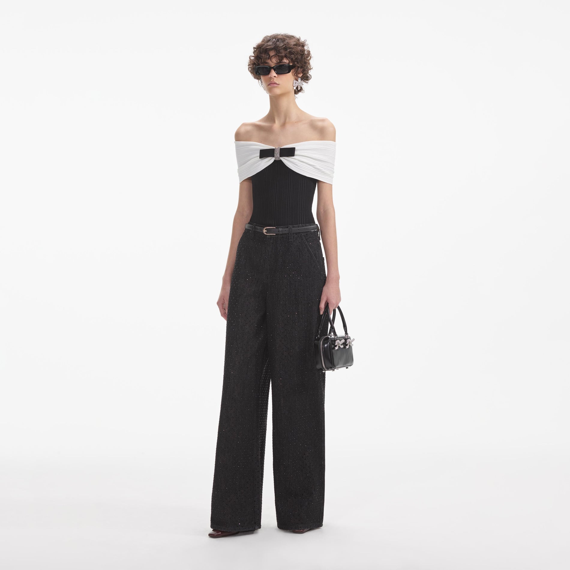 Side view of a woman wearing the Black Knit Bow Top