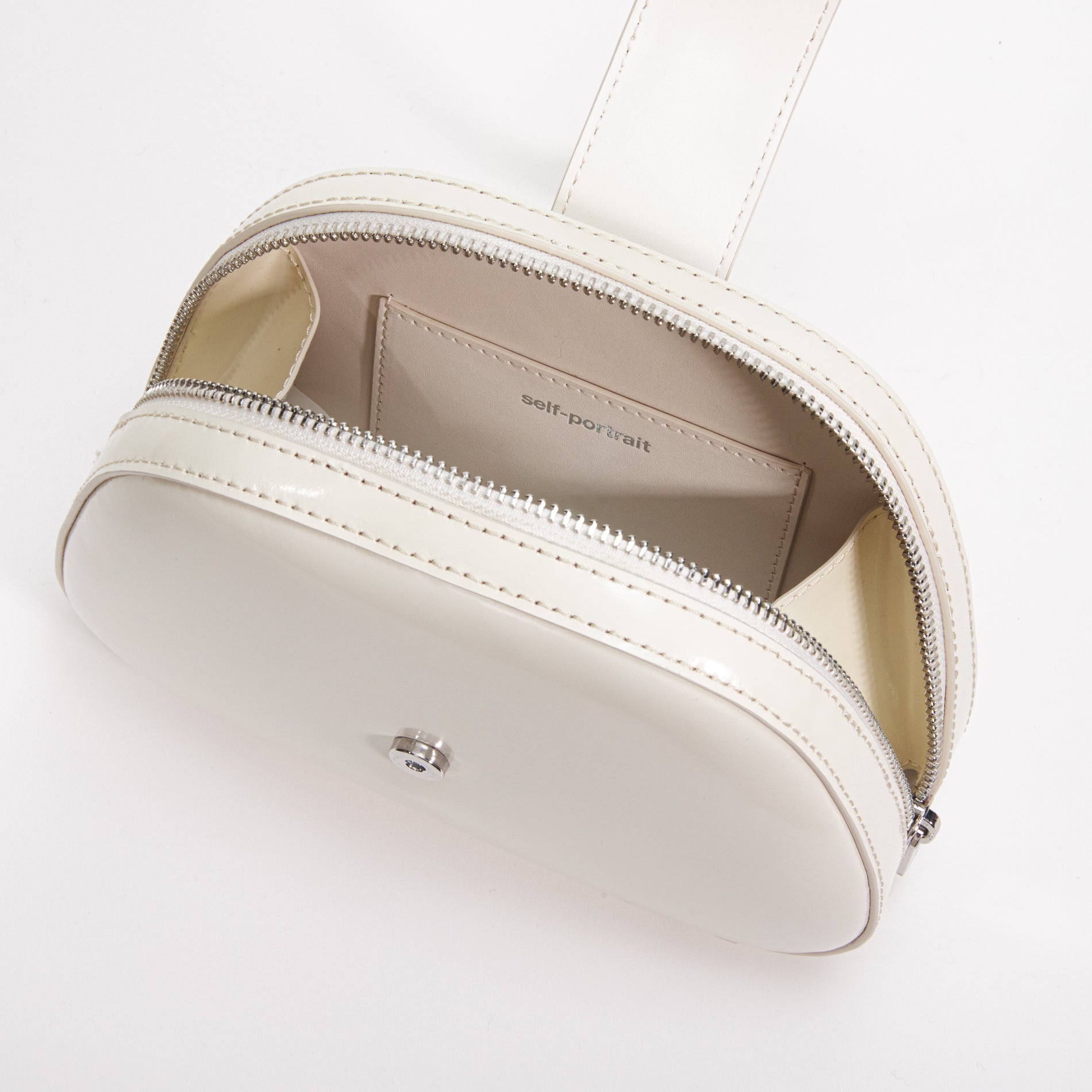 A close up of a woman wearing the Cream Leather Top Handle Mini Bag