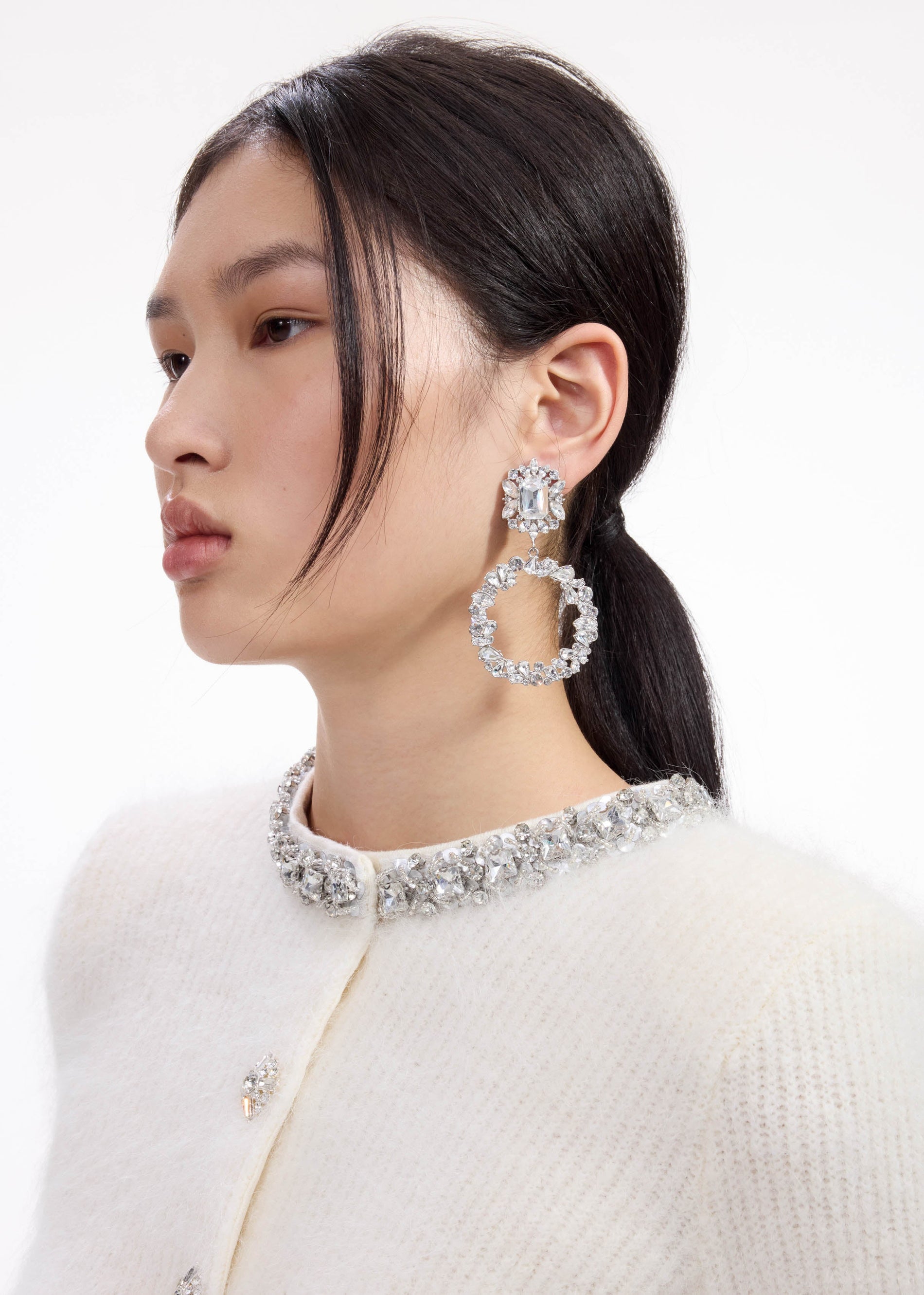 A close up of a woman wearing the Crystal Hoop Earrings