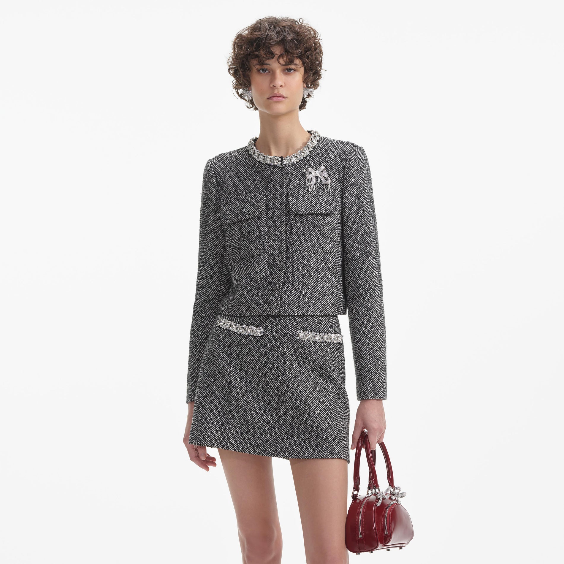 A close up of a woman wearing the Crystal Embellished Bow Brooch