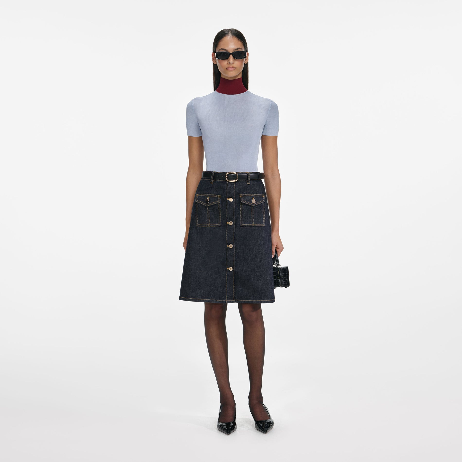 Front view of a woman wearing the Indigo Denim Belted Midi Skirt