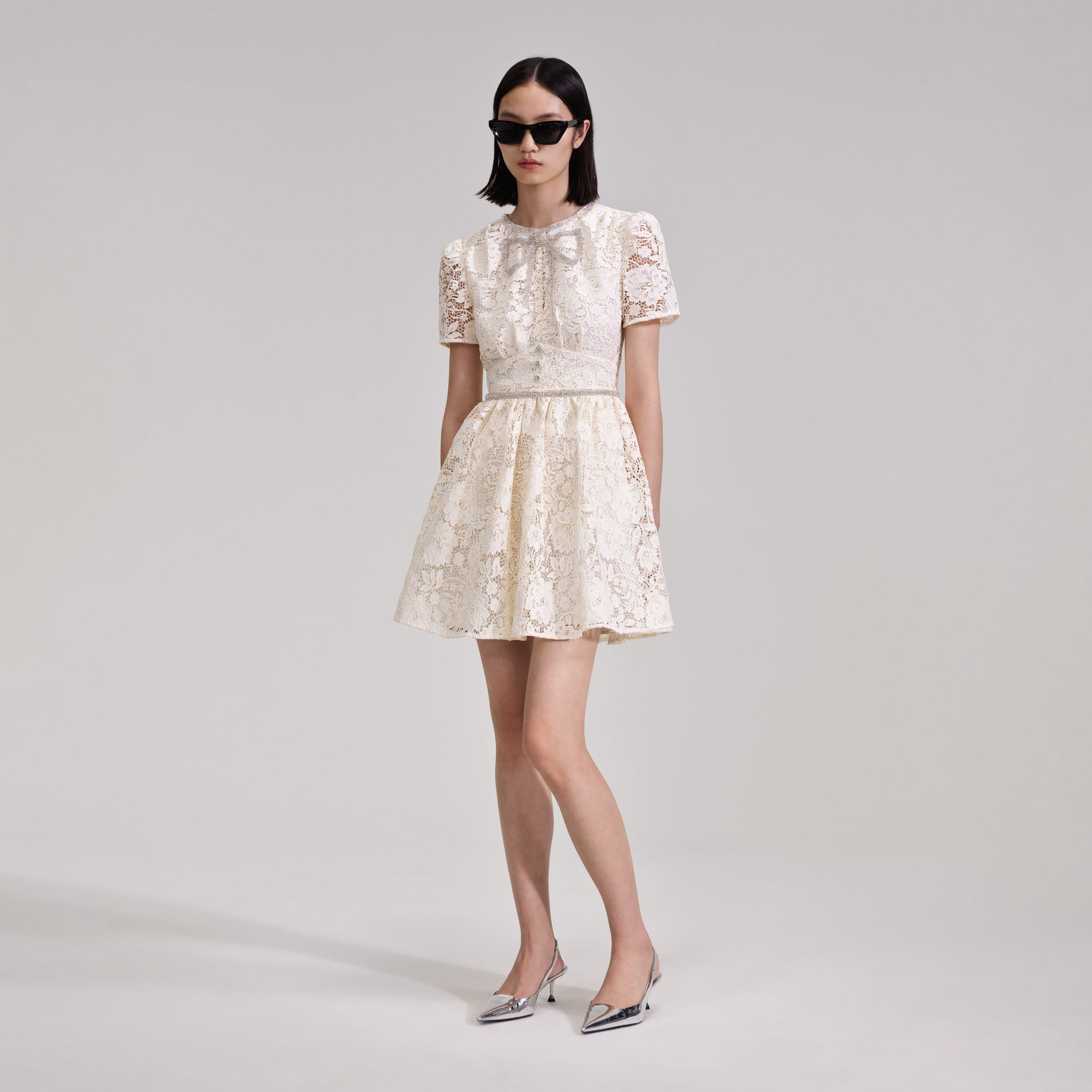 A woman wearing the Cream Cord Lace Bow Mini Dress