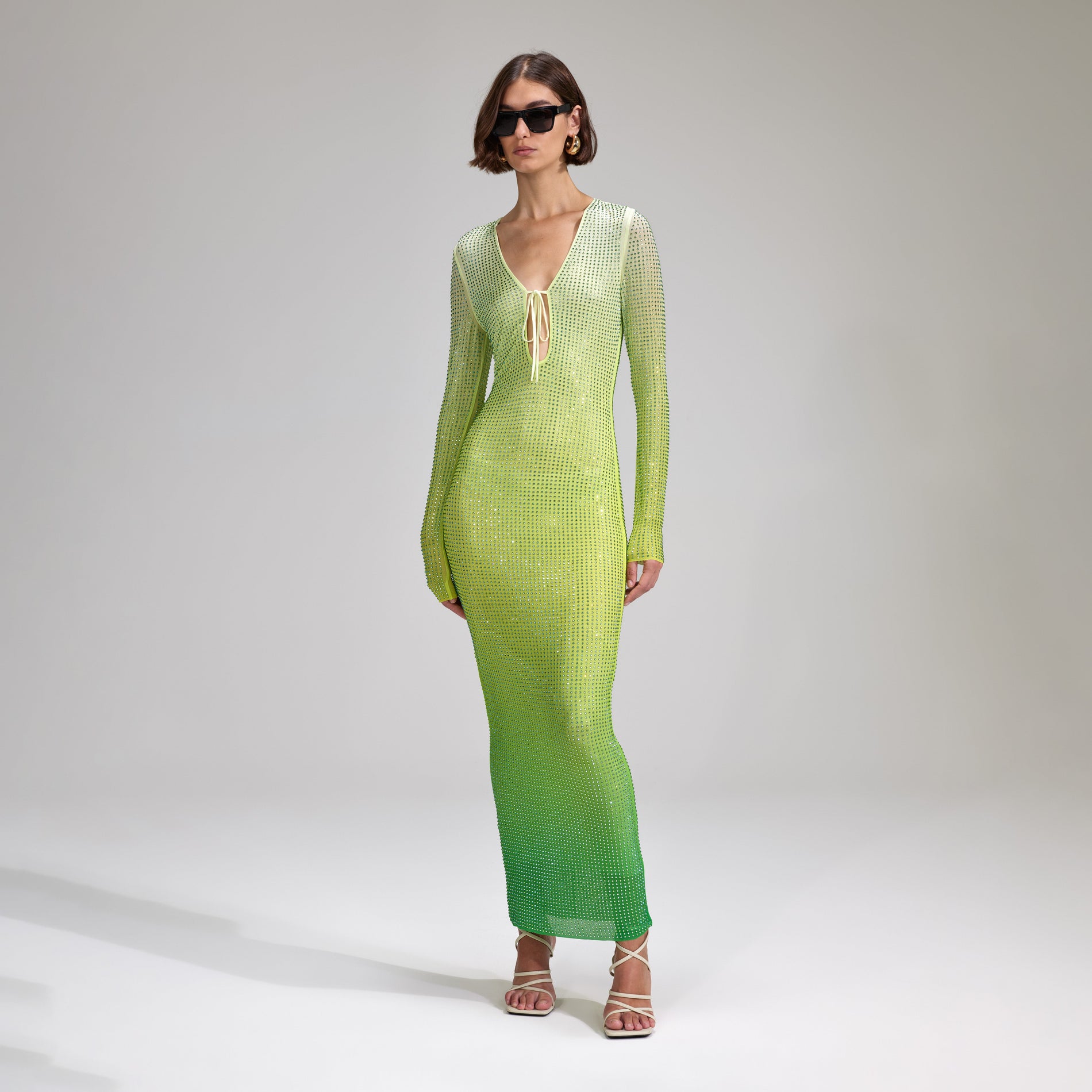 A woman wearing the Green Rhinestone Mesh Keyhole Maxi Dress