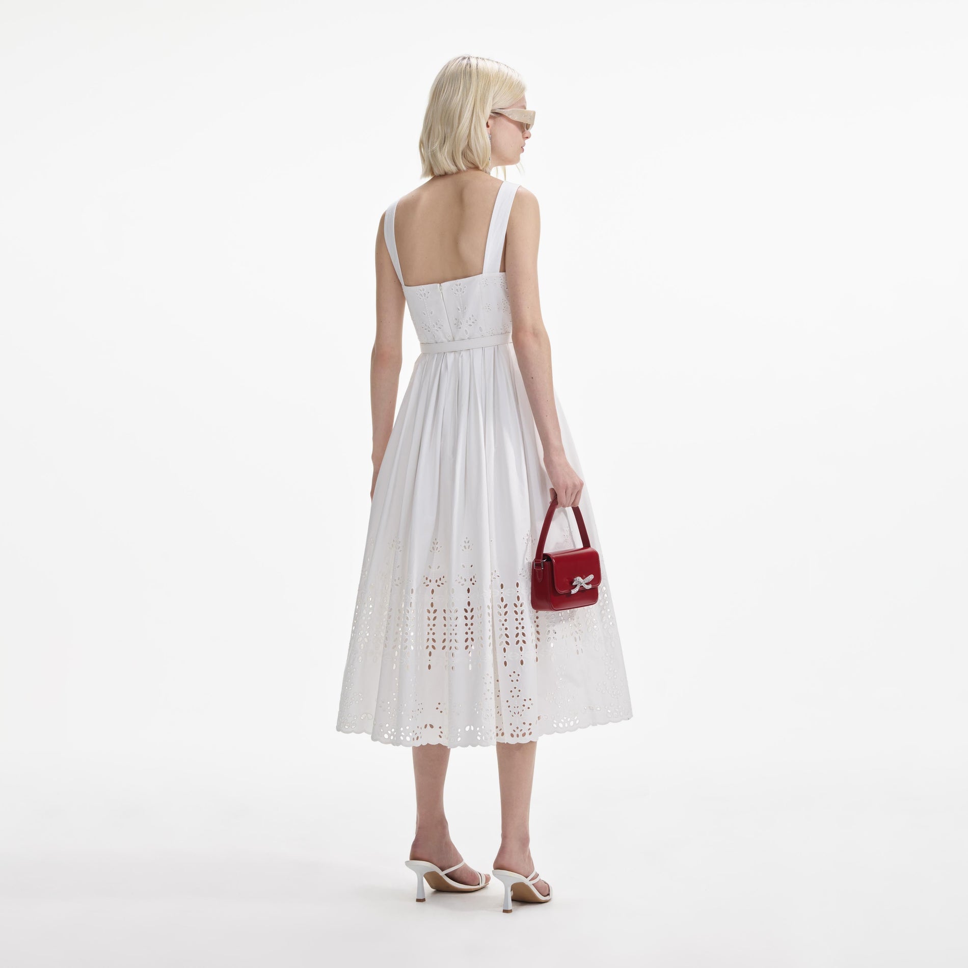 Back view of a woman wearing the White Cotton Broderie Midi Dress