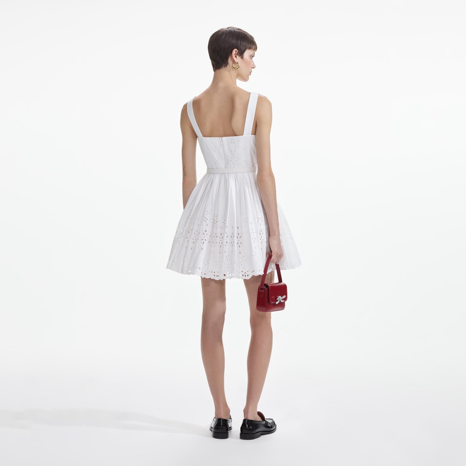 Back view of a woman wearing the White Cotton Broderie Mini Dress