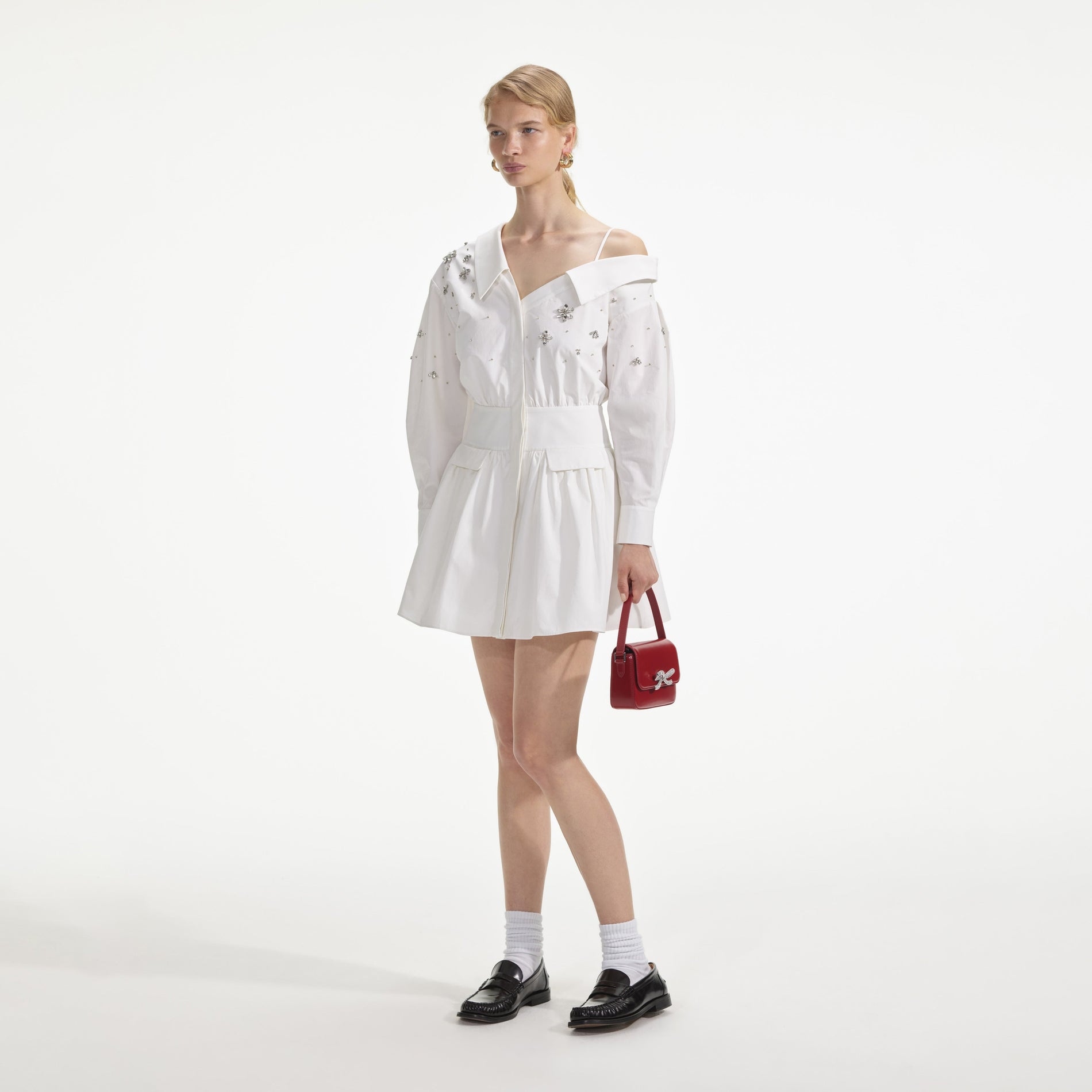 Side view of a woman wearing the White Cotton Embellished Mini Dress