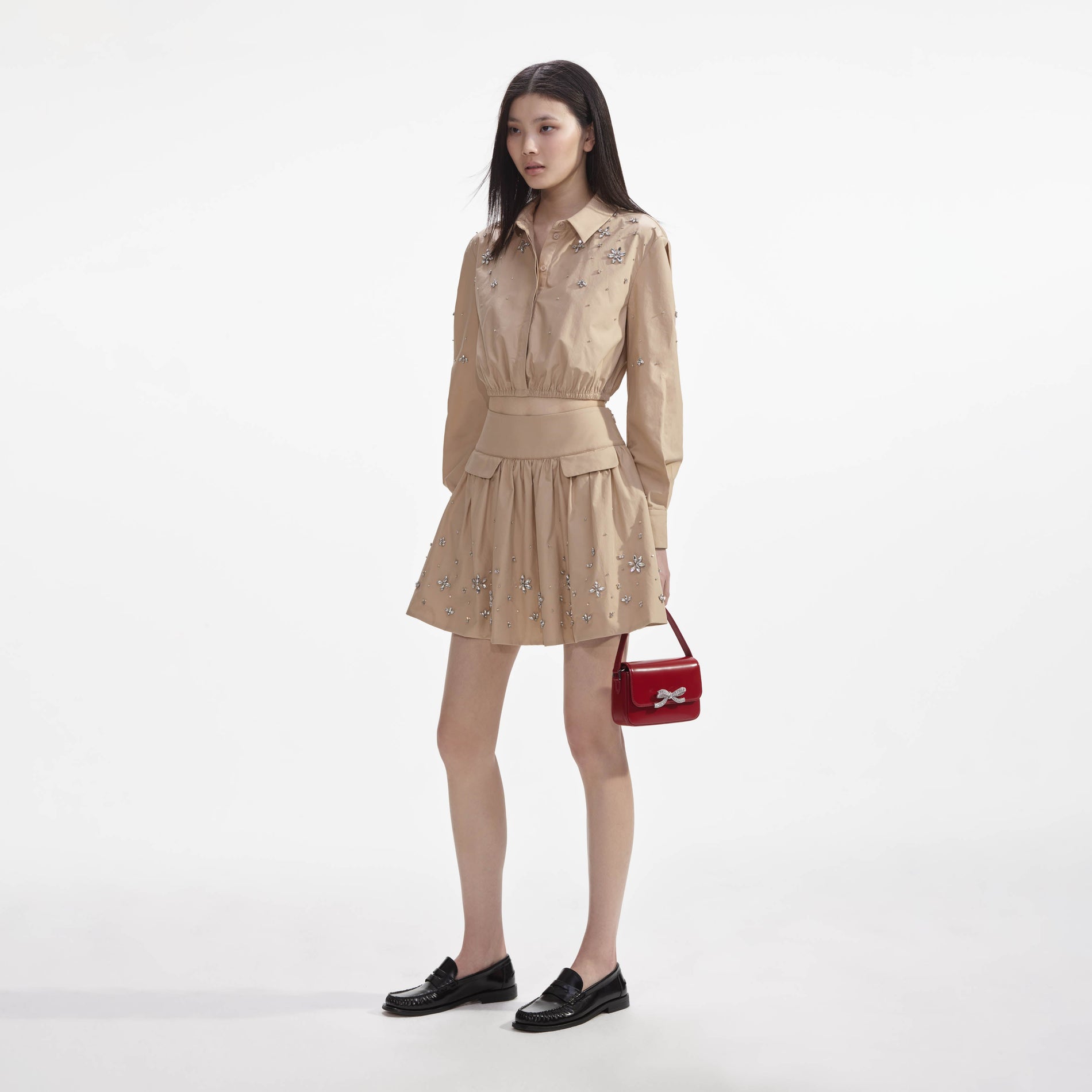 Side view of a woman wearing the Beige Cotton Embellished Mini Skirt