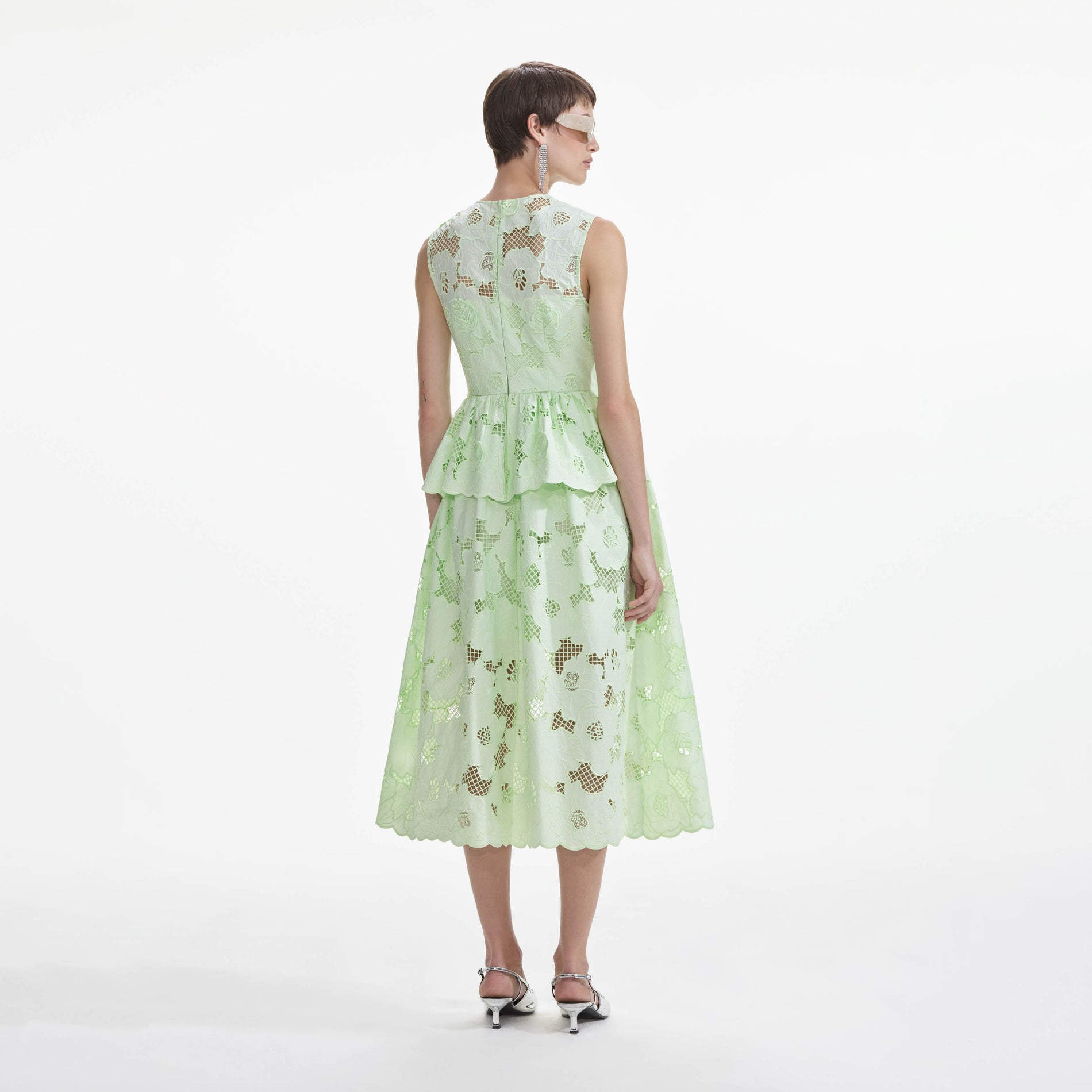 Back view of a woman wearing the Mint Cotton Lace Peplum Midi Dress