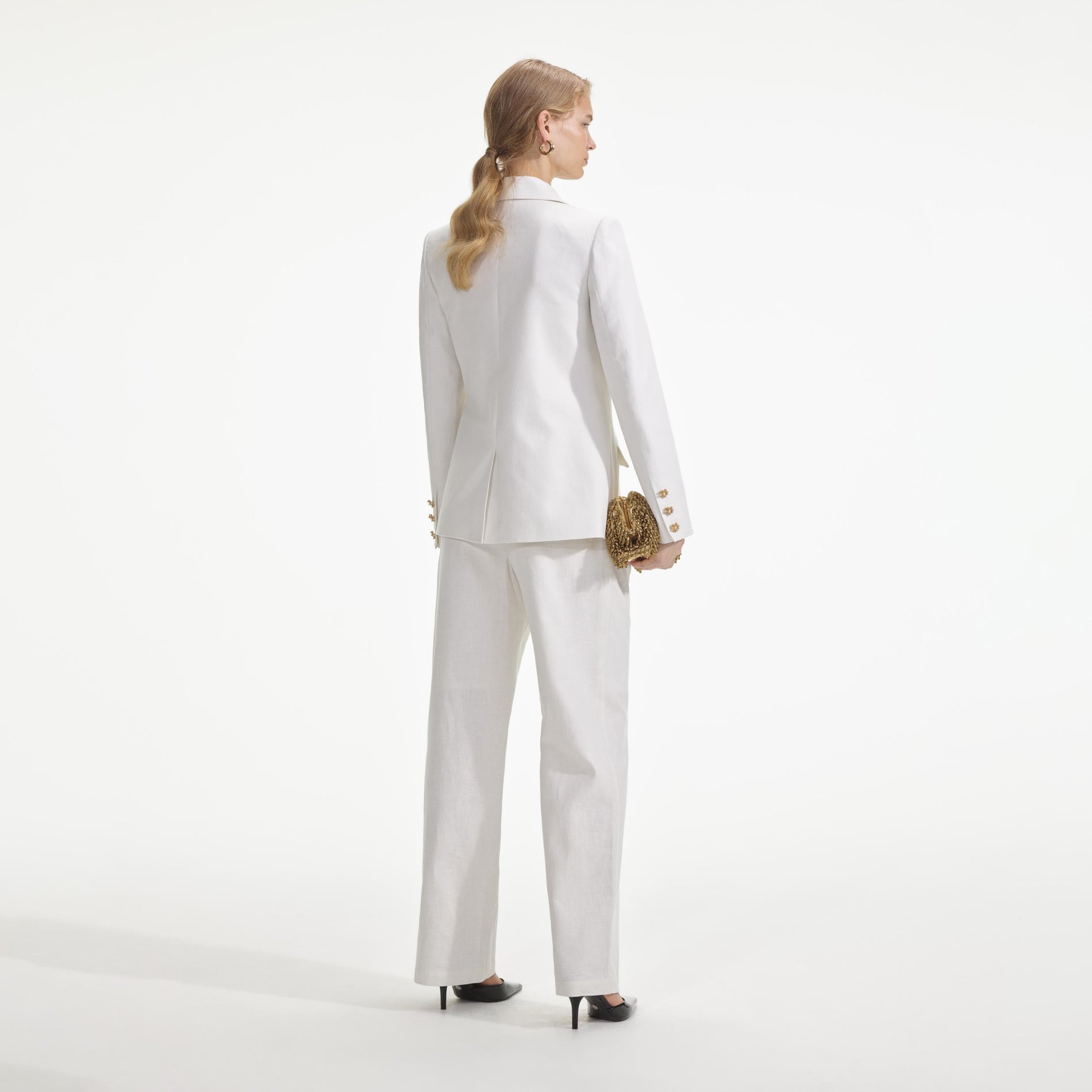 Back view of a woman wearing the White Linen Blazer