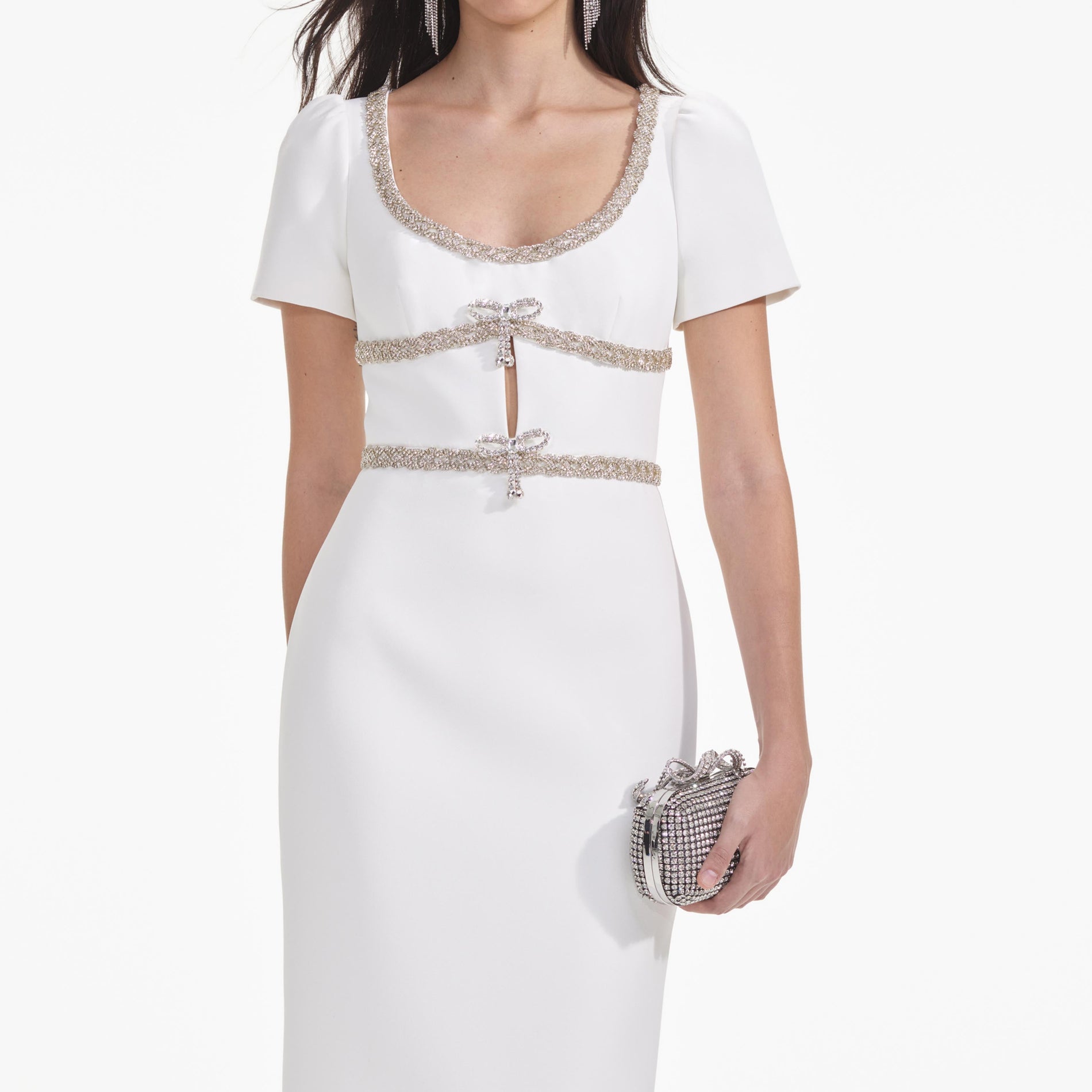 A close up of a woman wearing the White Diamante Bow Trim Midi Dress