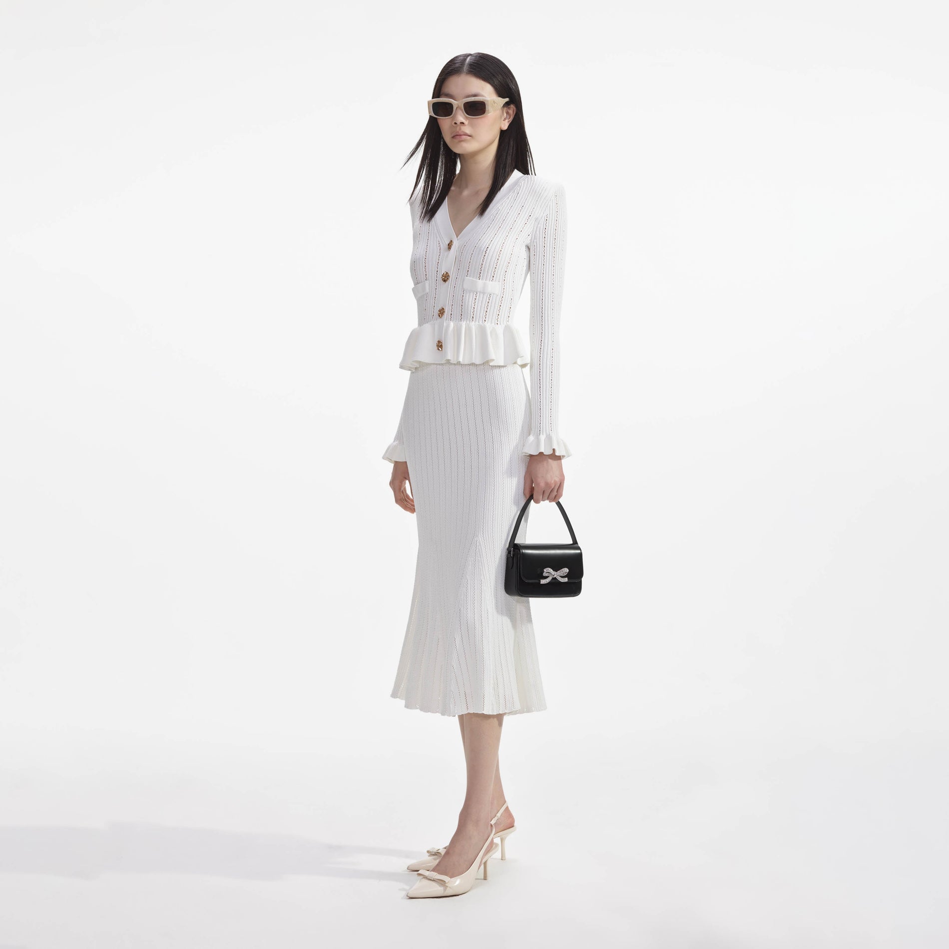 Side view of a woman wearing the White Knit Peplum Midi Dress