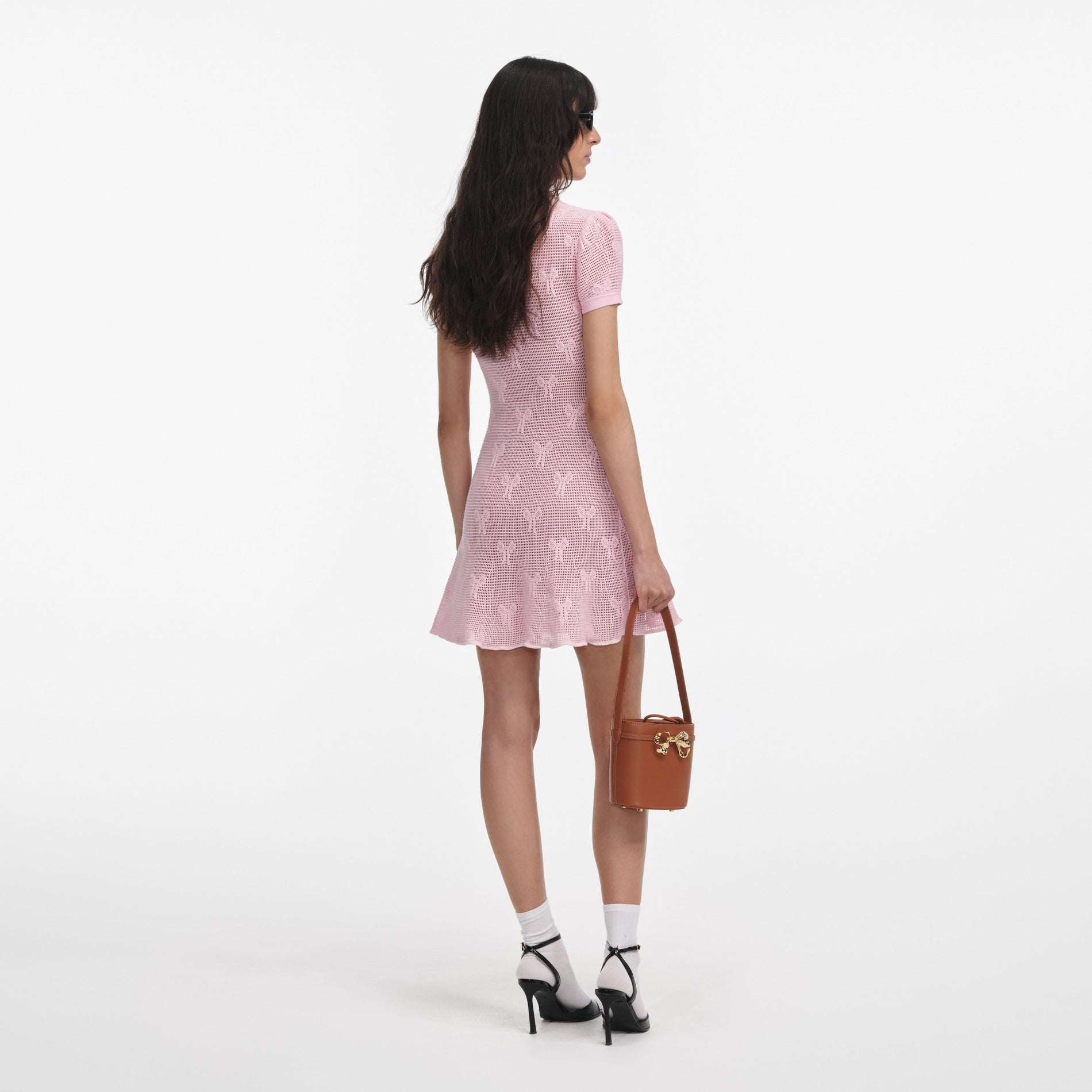 Back view of a woman wearing the Pink Bow Crochet Crystal Trim Mini Dress