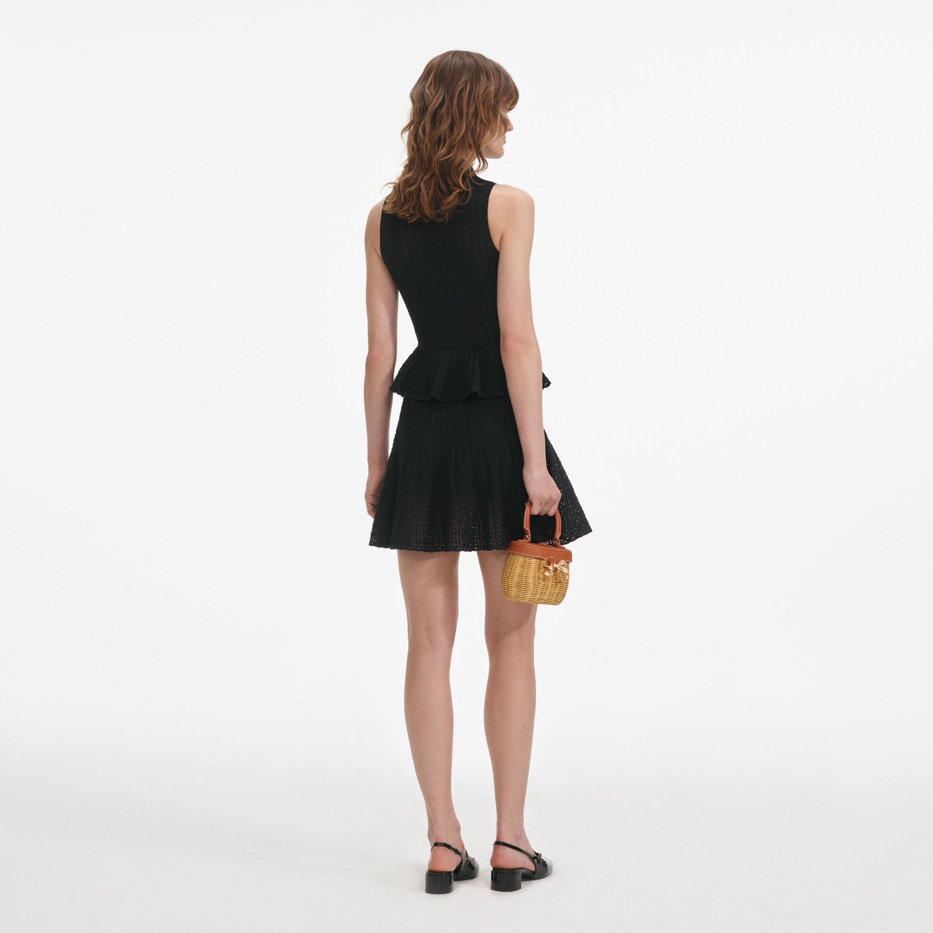 Back view of a woman wearing the Black Pointelle Knit Mini Dress