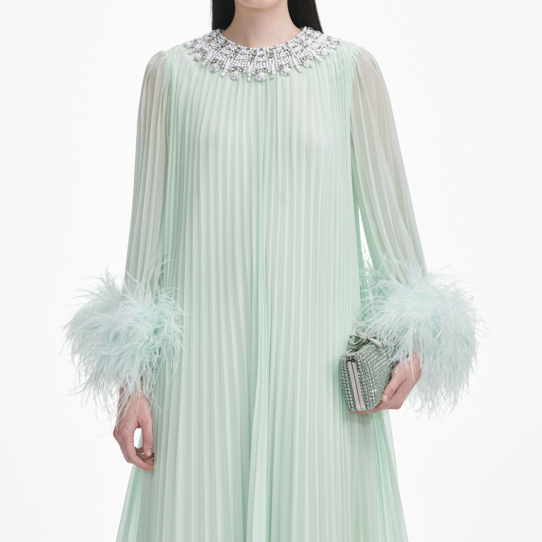 A close up of a woman wearing the Mint Chiffon Feather Midi Dress
