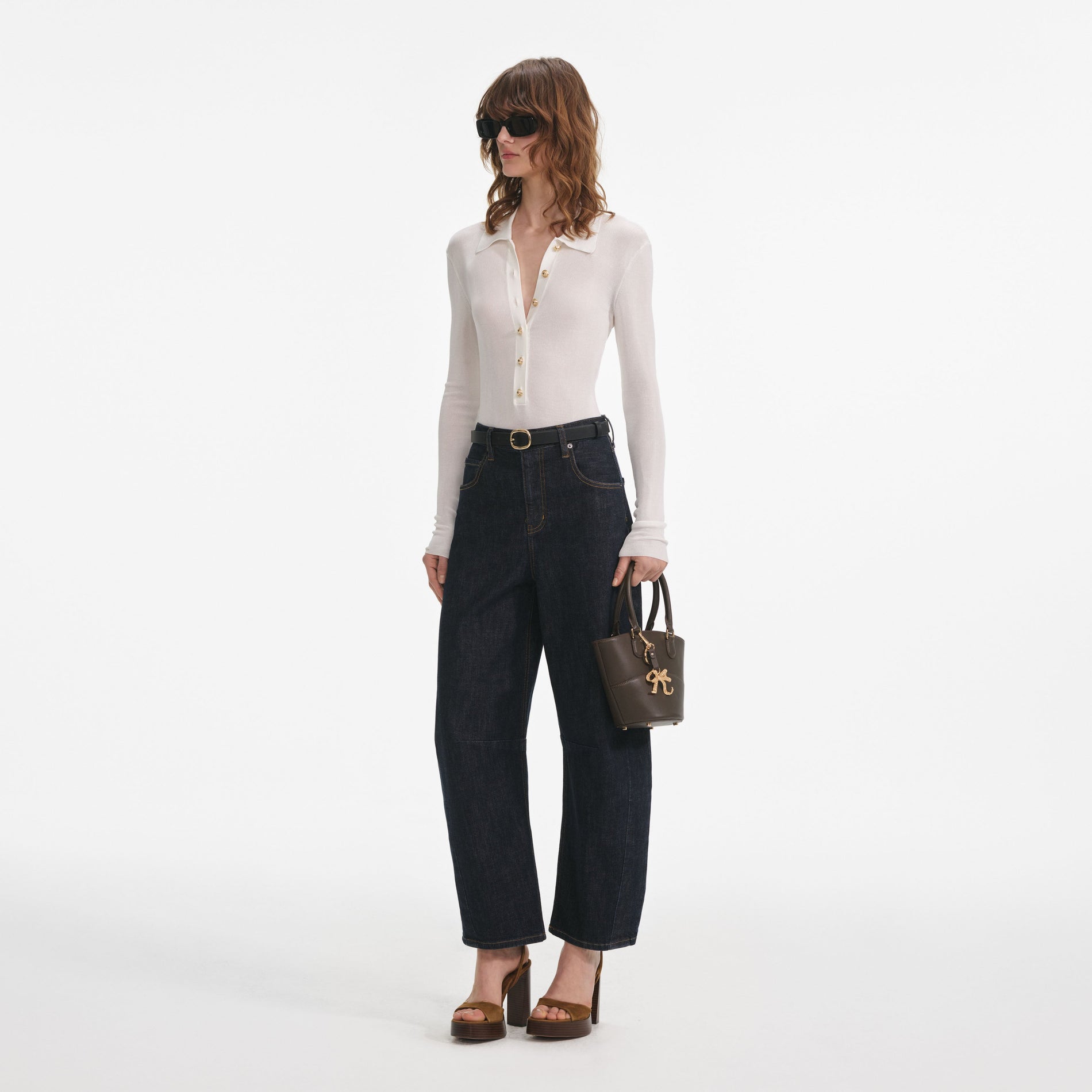 Side view of a woman wearing the White Viscose Knit Bodysuit