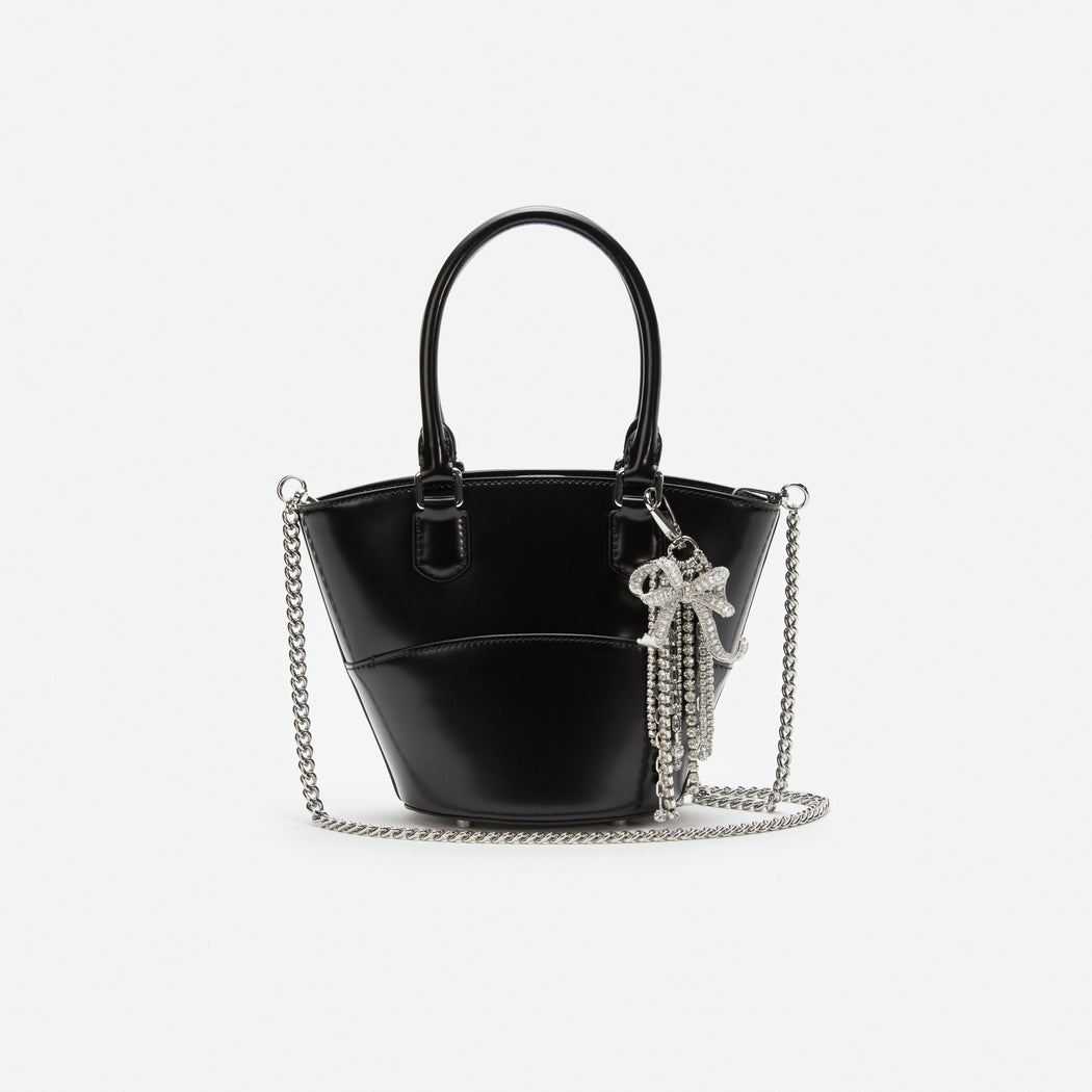 Black patent leather handbag with a silver chain strap and a rhinestone bow charm