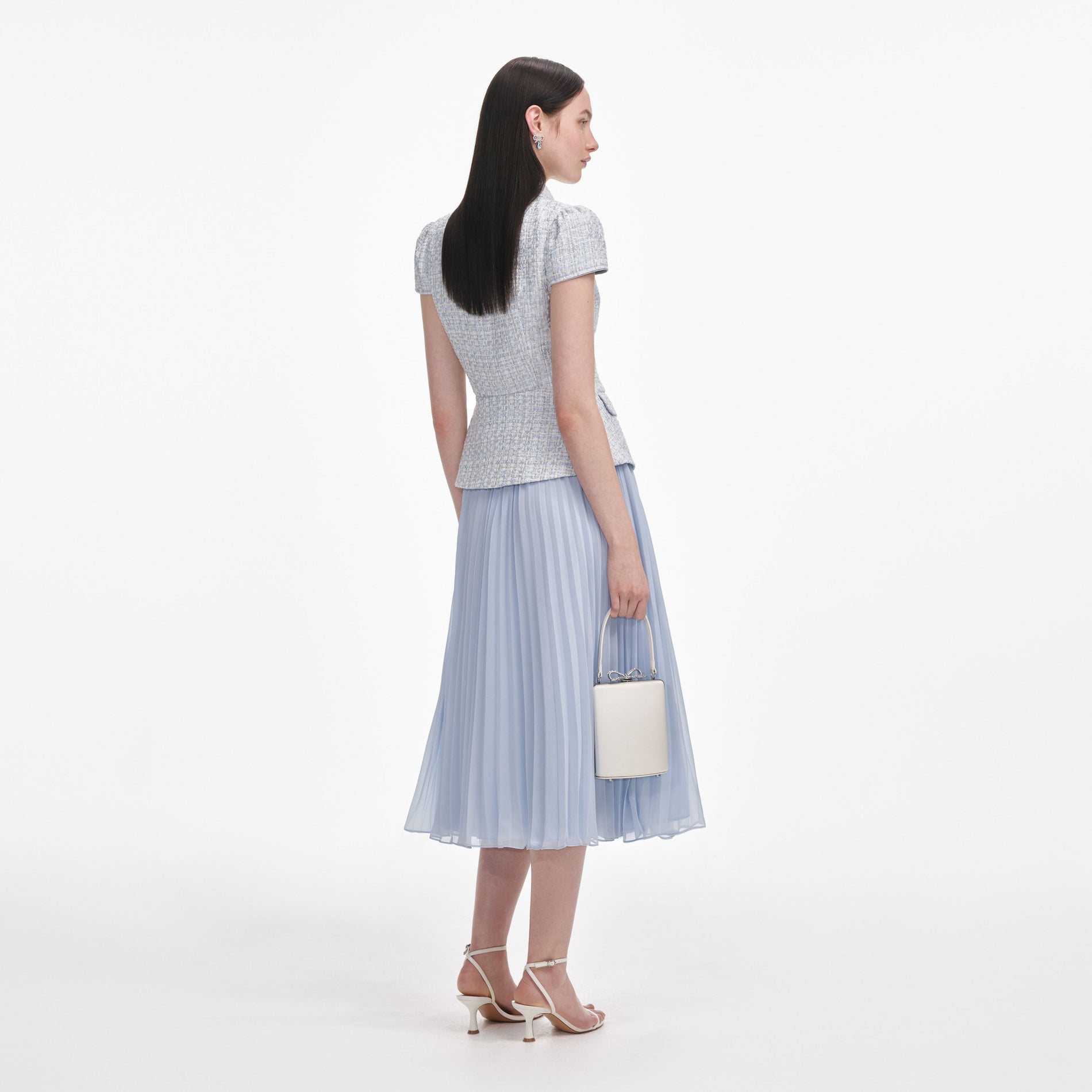 Back view of a woman wearing the Blue Boucle Bow Midi Dress