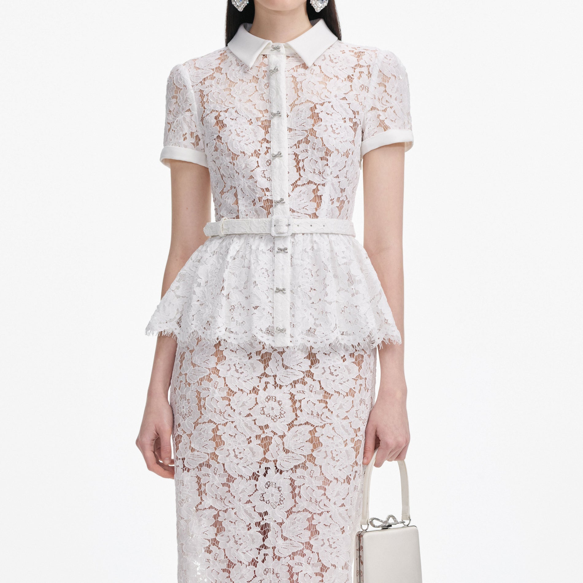 A close up of a woman wearing the White Lace Peplum Midi Dress