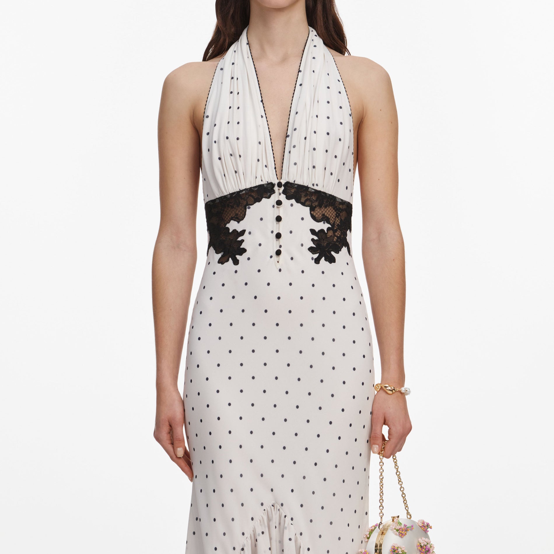 A close up of a woman wearing the Polka Dot Halter Neck Midi Dress