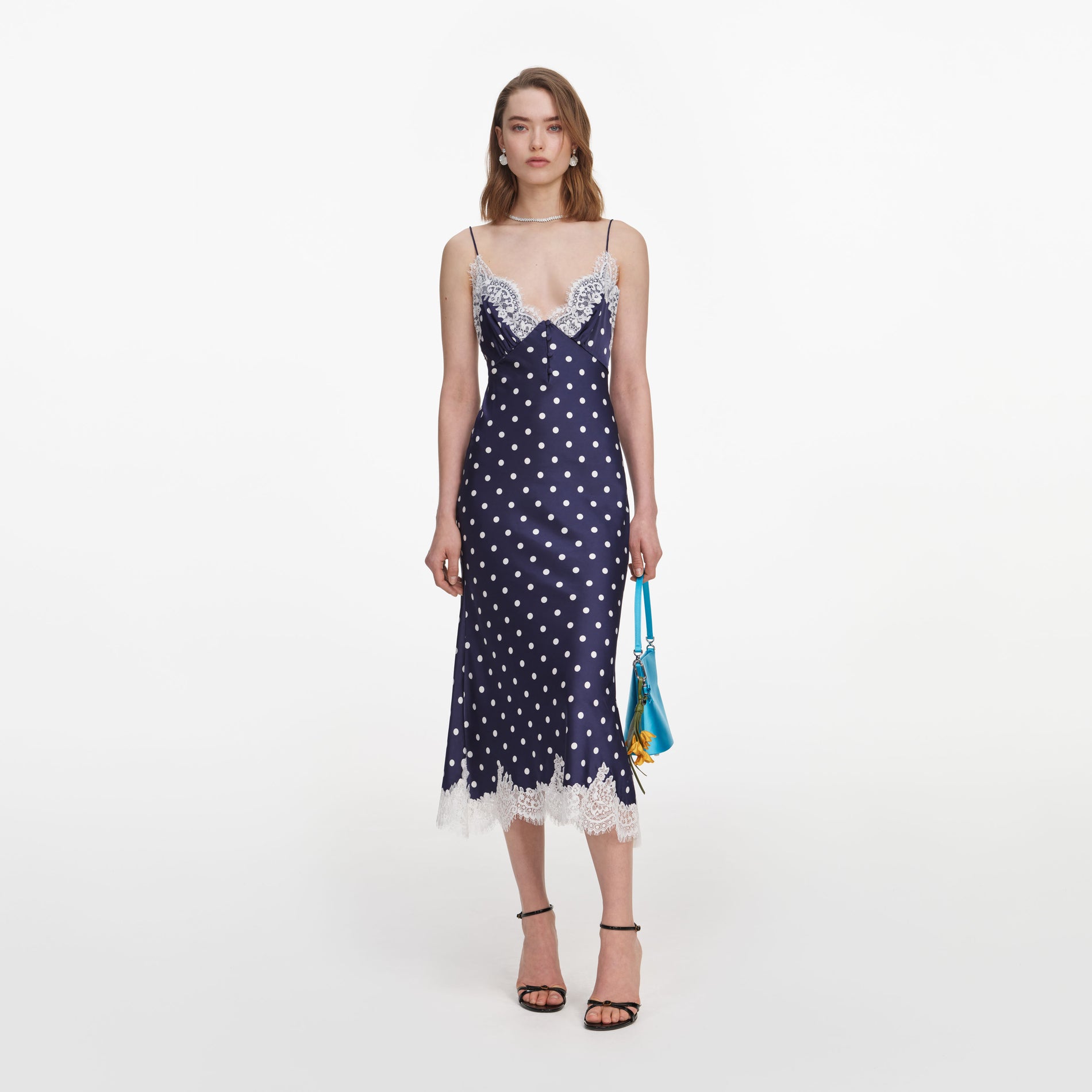 Front view of a woman wearing the Navy Polka Dot Satin Midi Dress