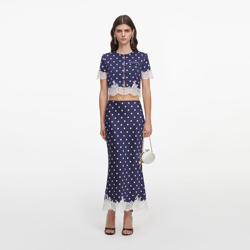 Front view of a woman wearing the Navy Polka Dot Satin Midi Skirt