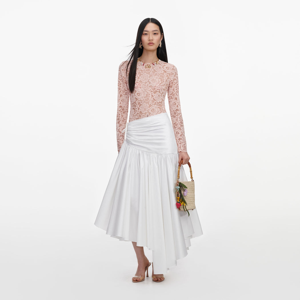 Front view of a woman wearing the White Cotton Asymmetric Midi Skirt