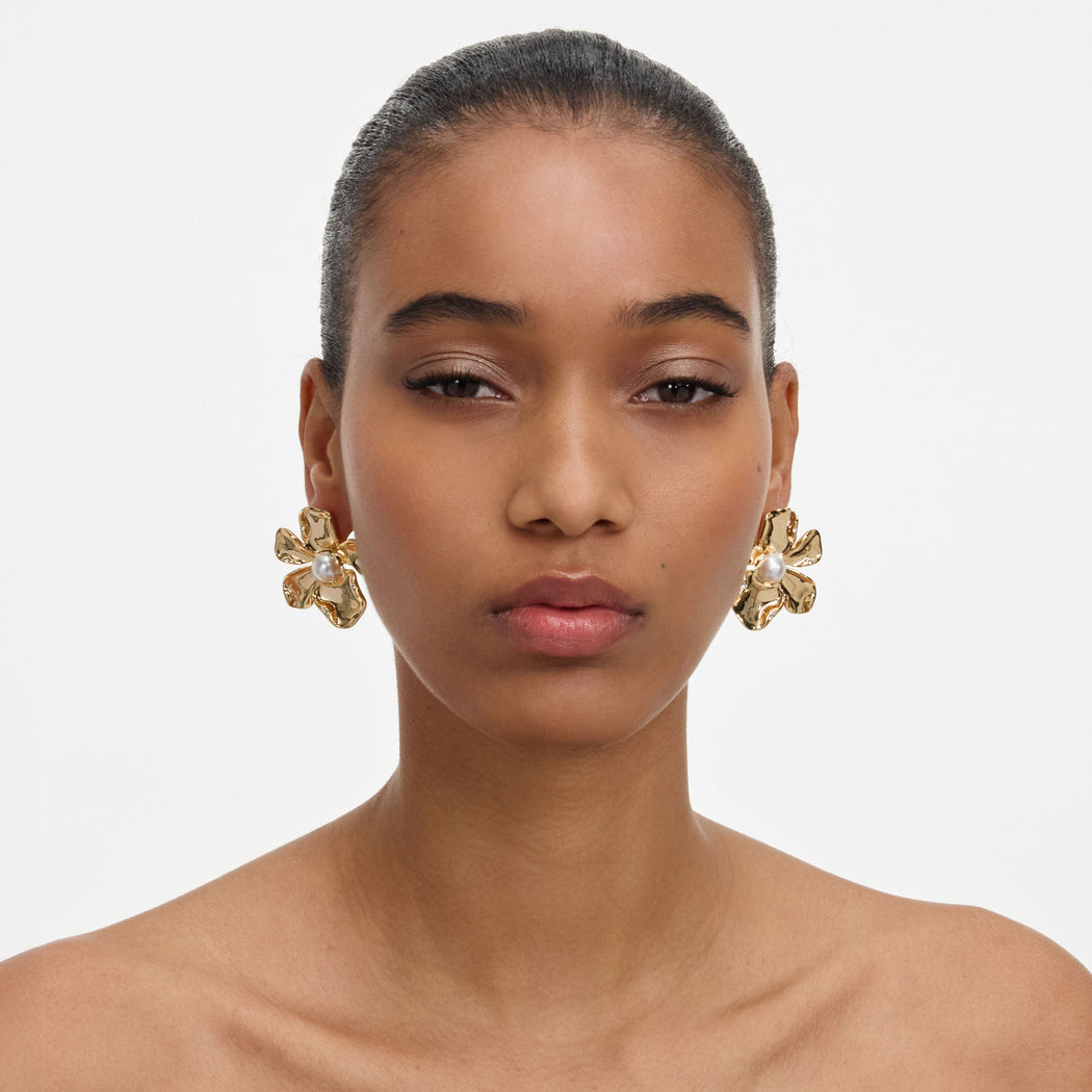 A close up of a woman wearing the Gold Pearl Flower Earrings