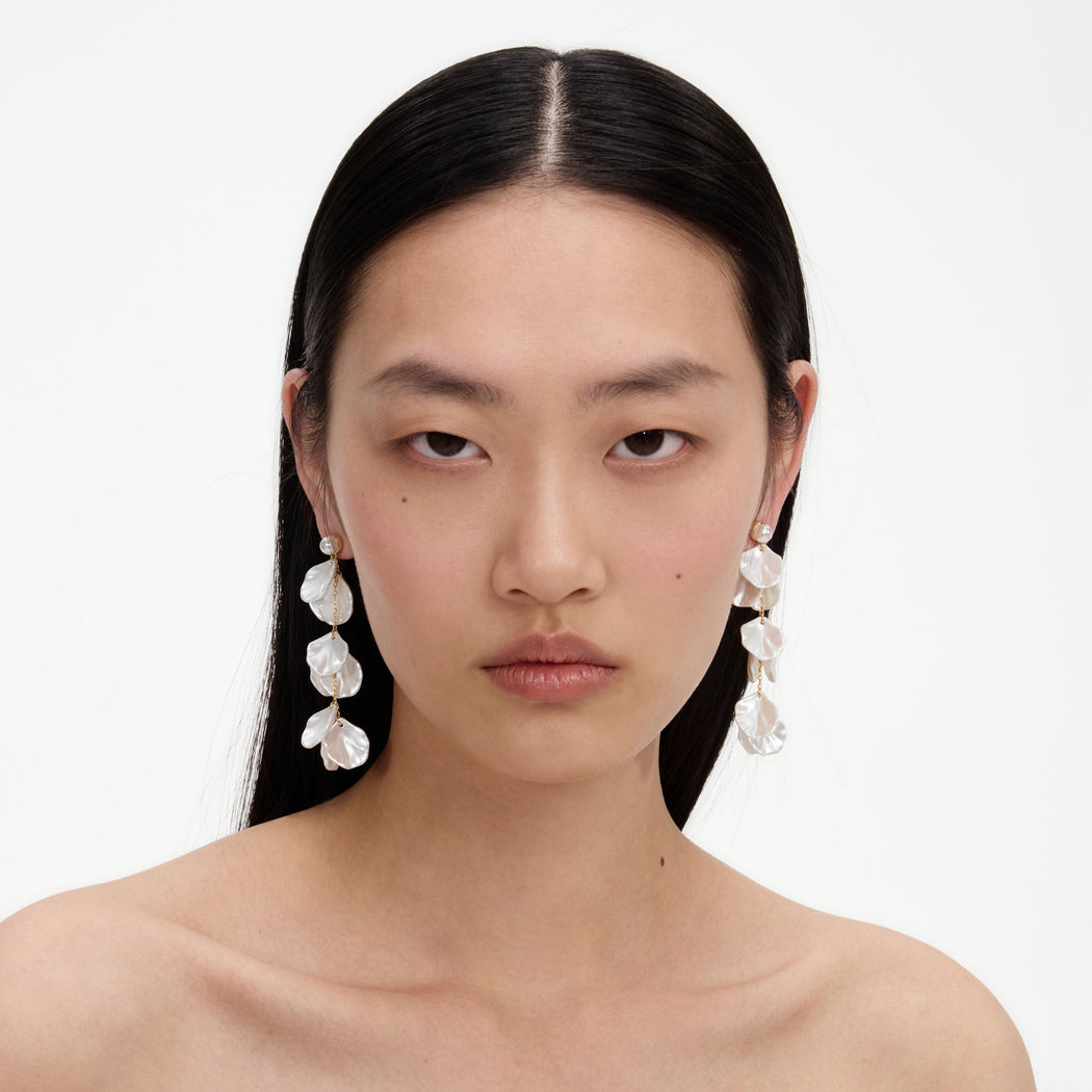 A close up of a woman wearing the Pearl Petal Tiered Earrings