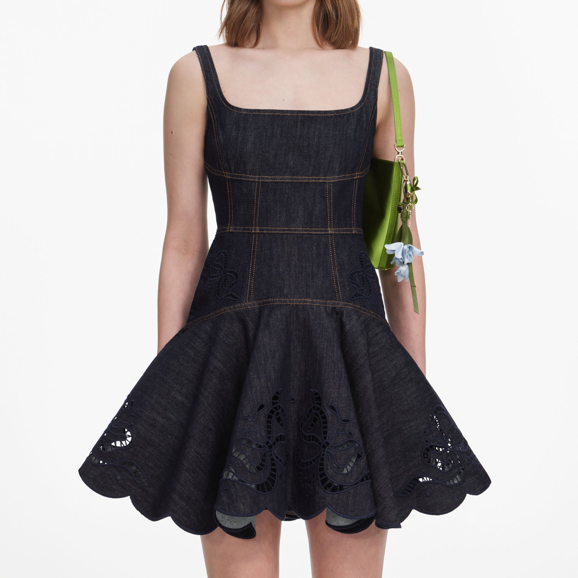 A close up of a woman wearing the Indigo Denim Bow Embroidered Mini Dress