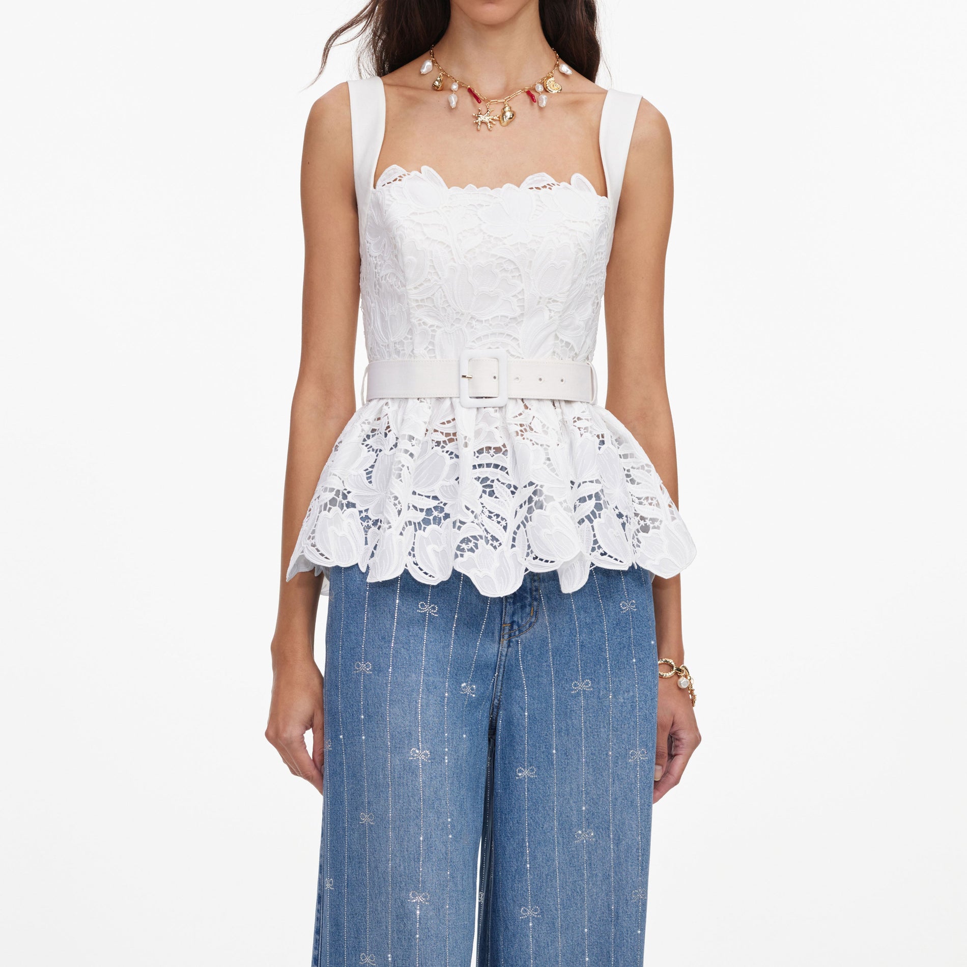 A close up of a woman wearing the White Lace Peplum Top