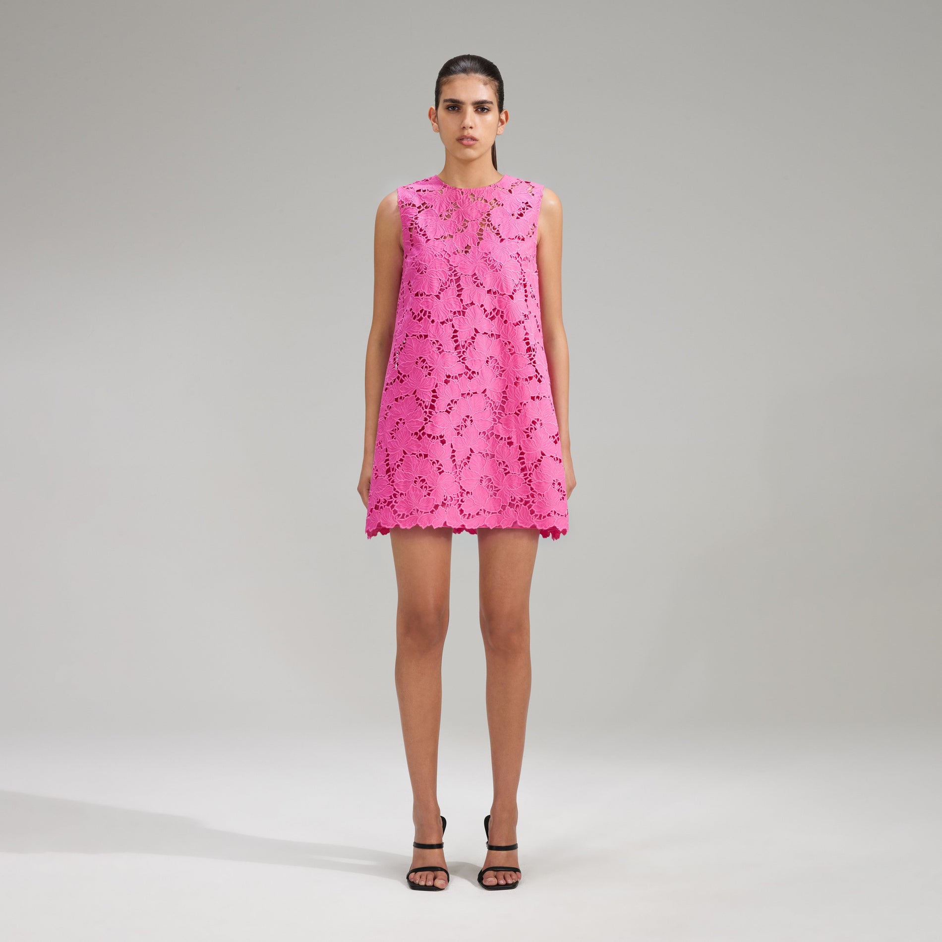 A woman wearing the Pink Cotton Lace Mini Dress