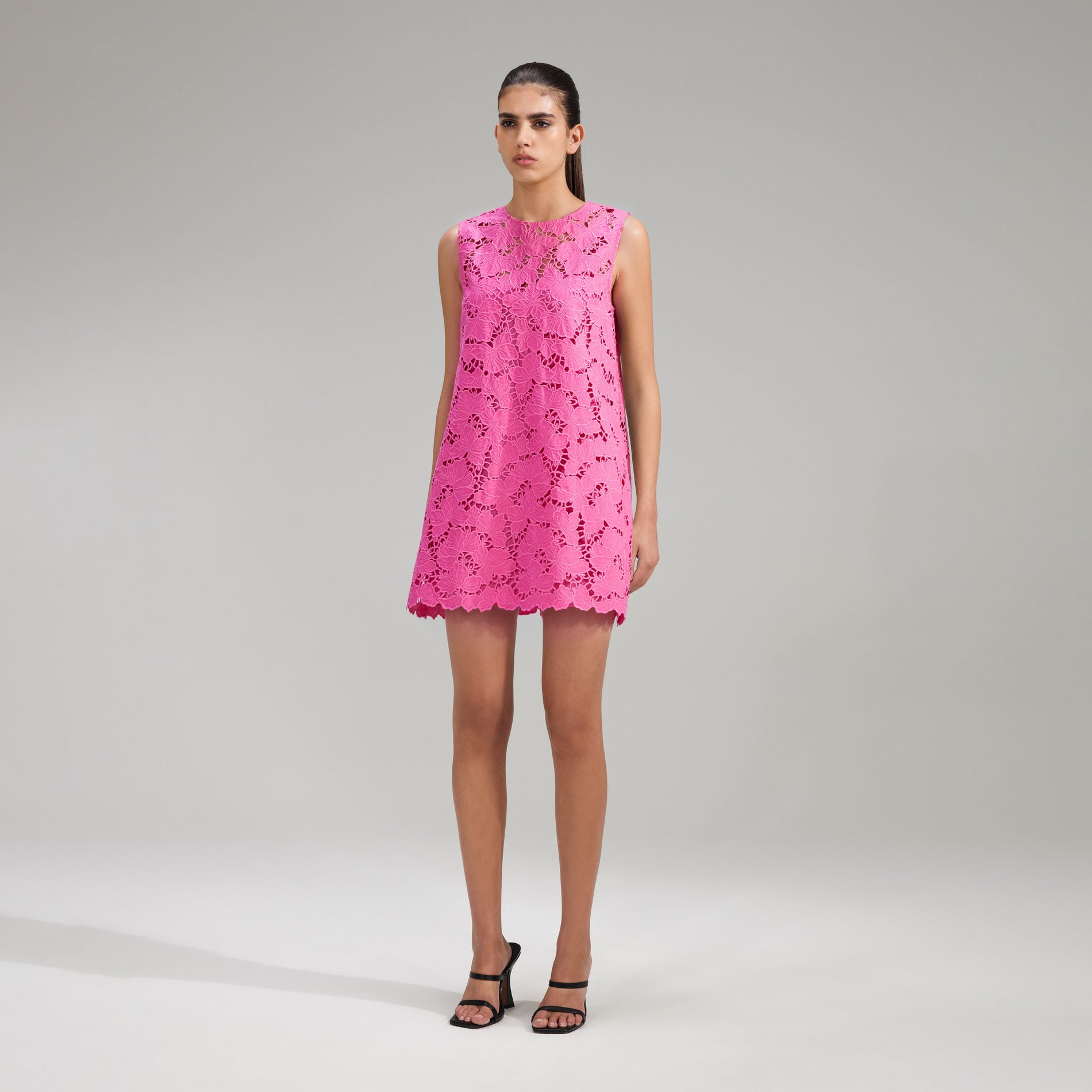 A woman wearing the Pink Cotton Lace Mini Dress