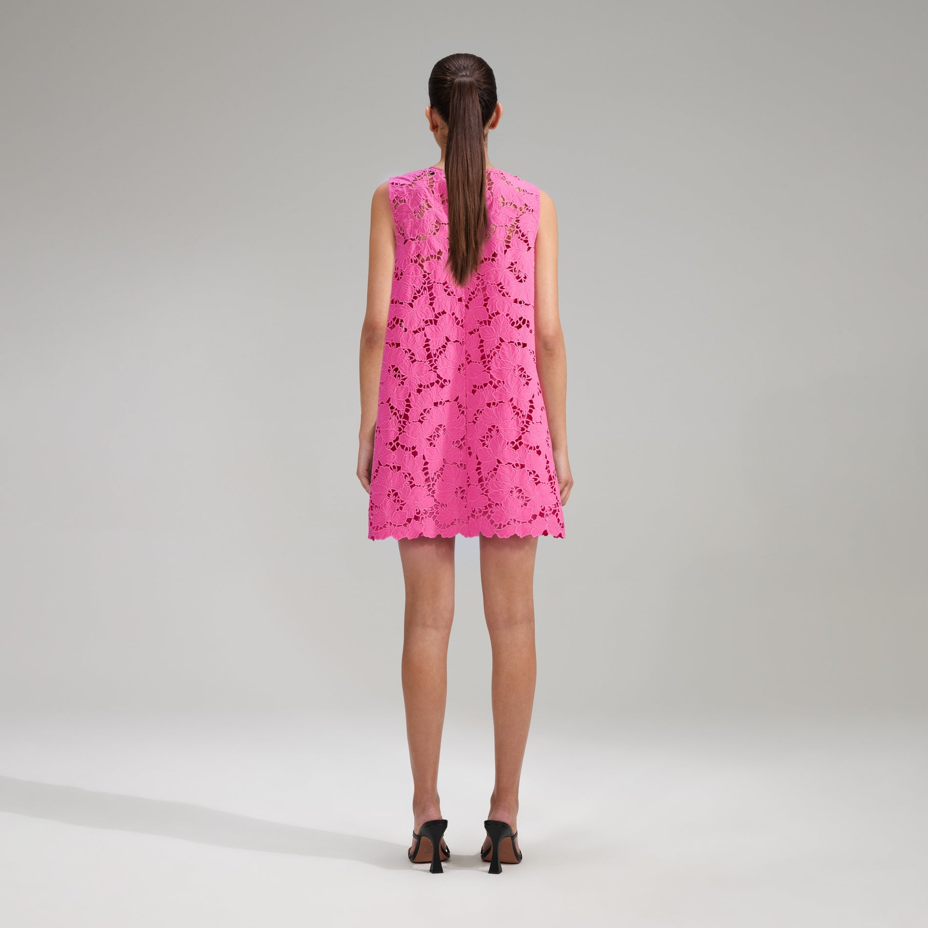 A woman wearing the Pink Cotton Lace Mini Dress