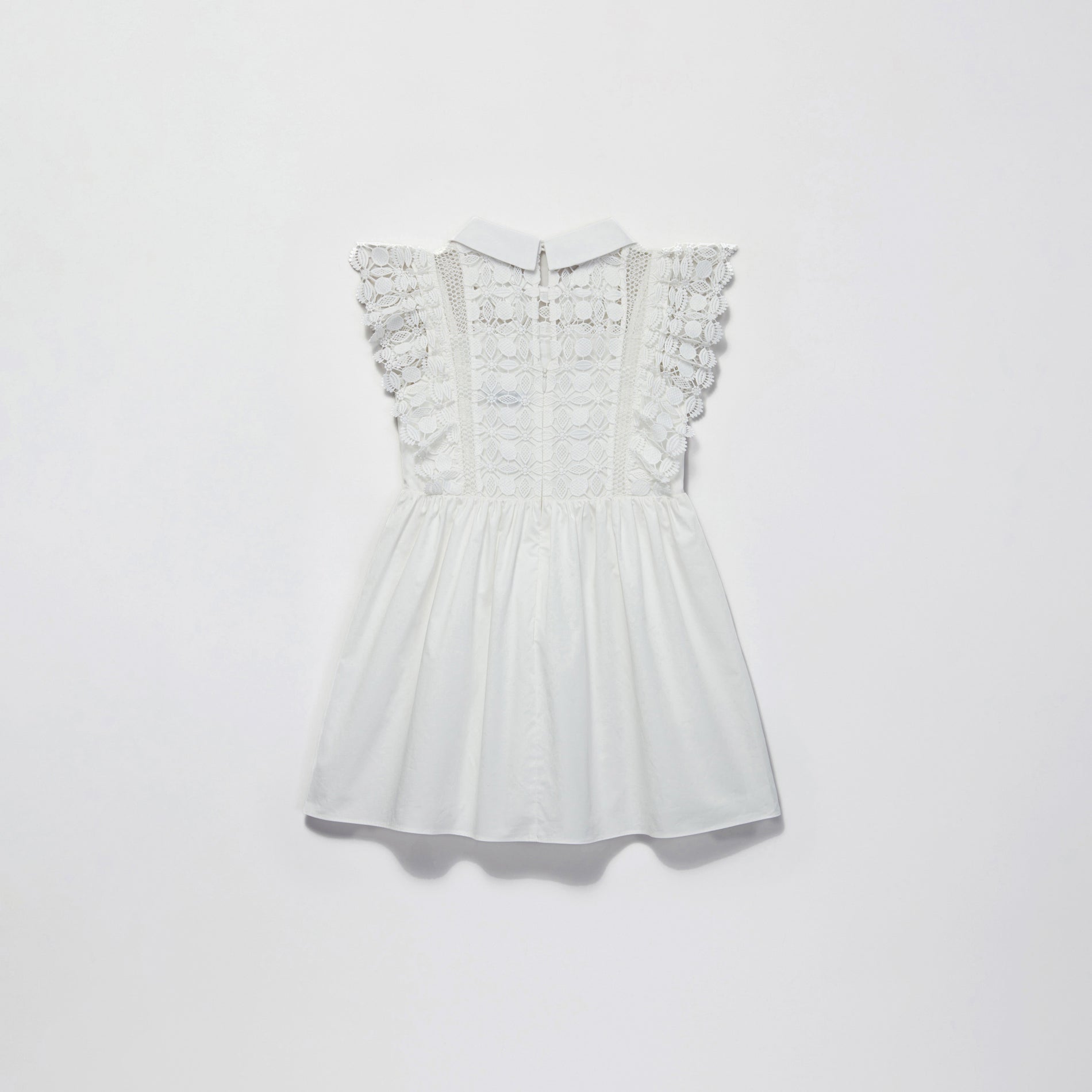 Side view of a woman wearing the White Lace Mini Dress