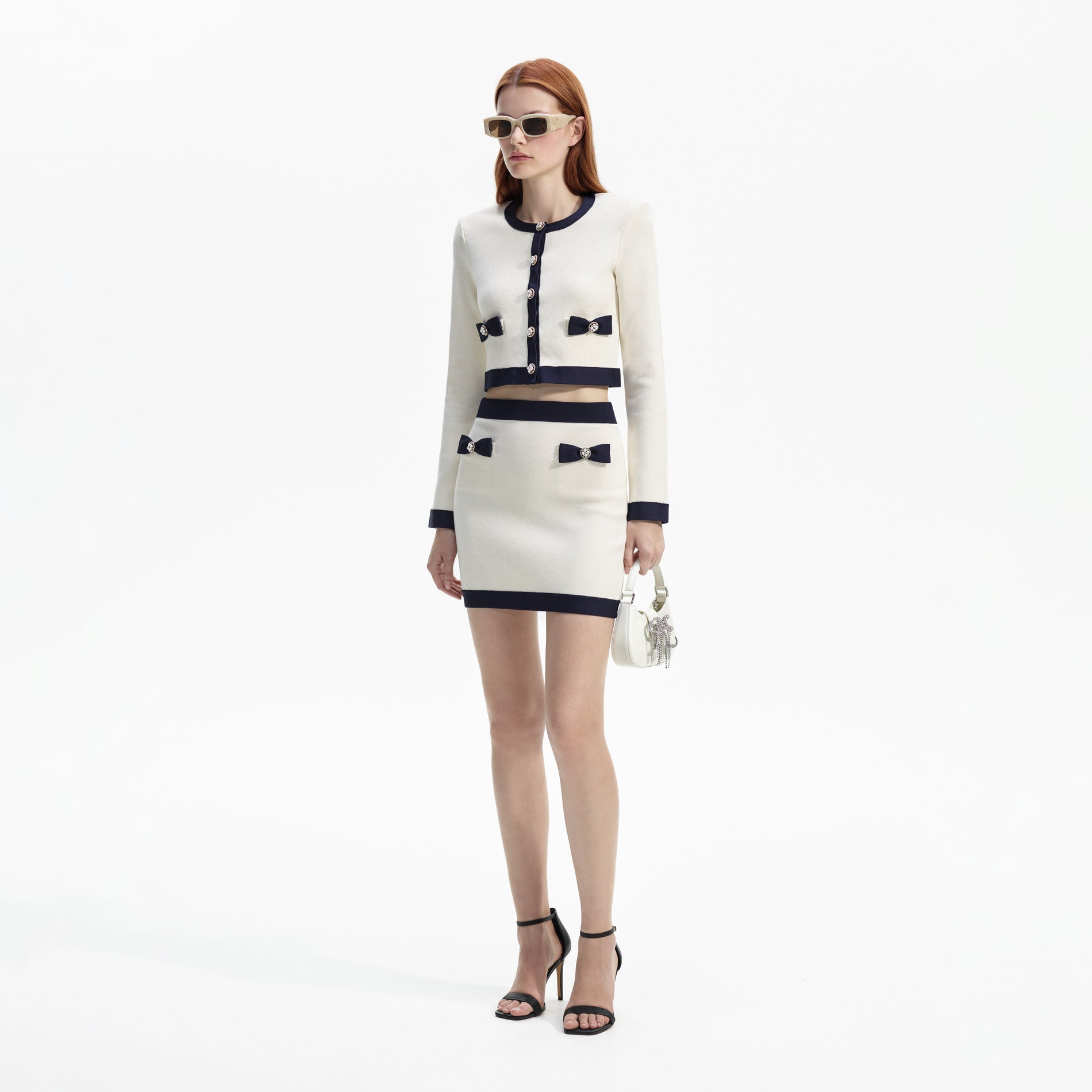 Side view of a woman wearing the Cream Knit Bow Cardigan