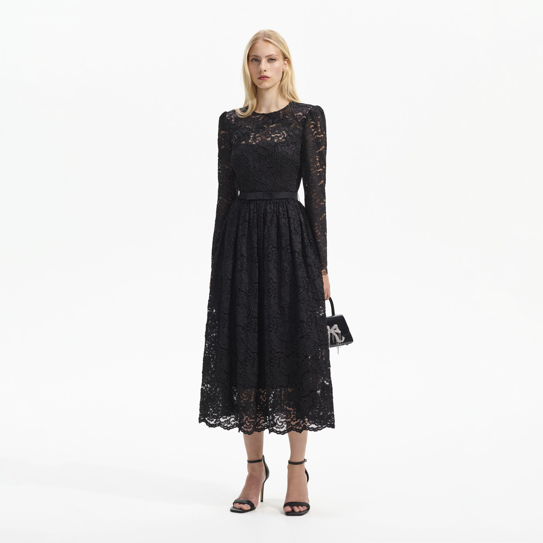Side view of a woman wearing the Black Cord Lace Long Sleeve Midi Dress