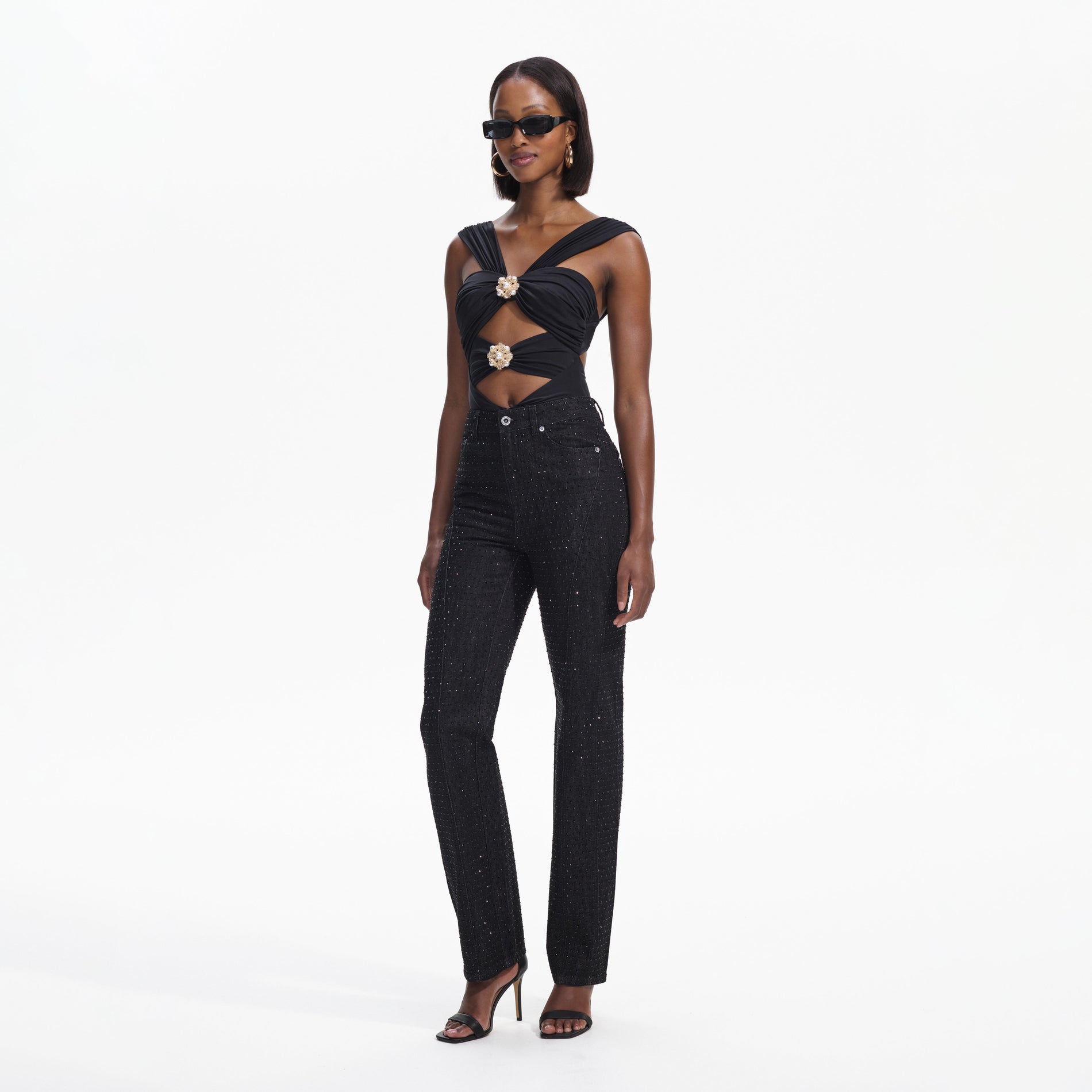 Side view of a woman wearing the Black Rhinestone Denim Jeans