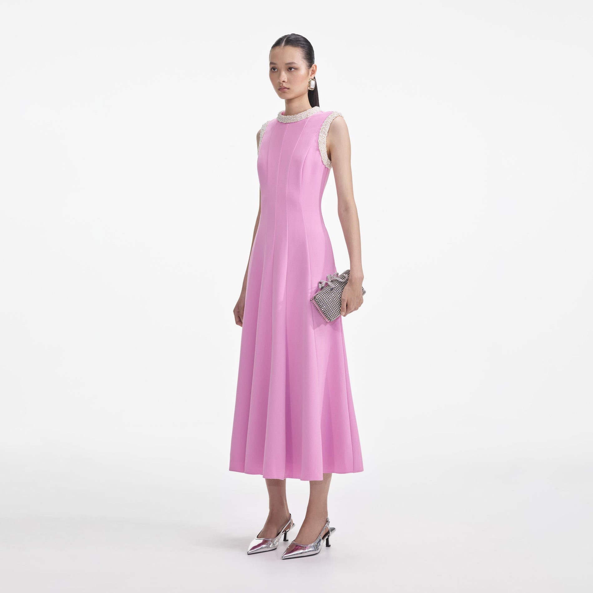 Side view of a woman wearing the Pink Crepe Pearl Trim Midi Dress