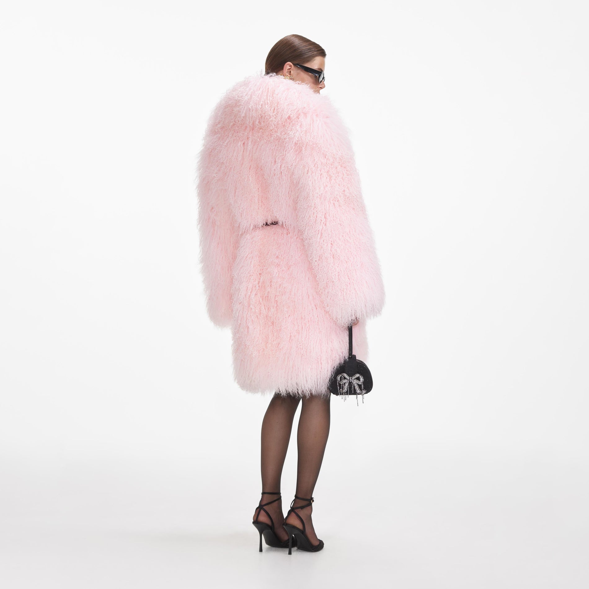 Back view of a woman wearing the Pink Shearling Coat