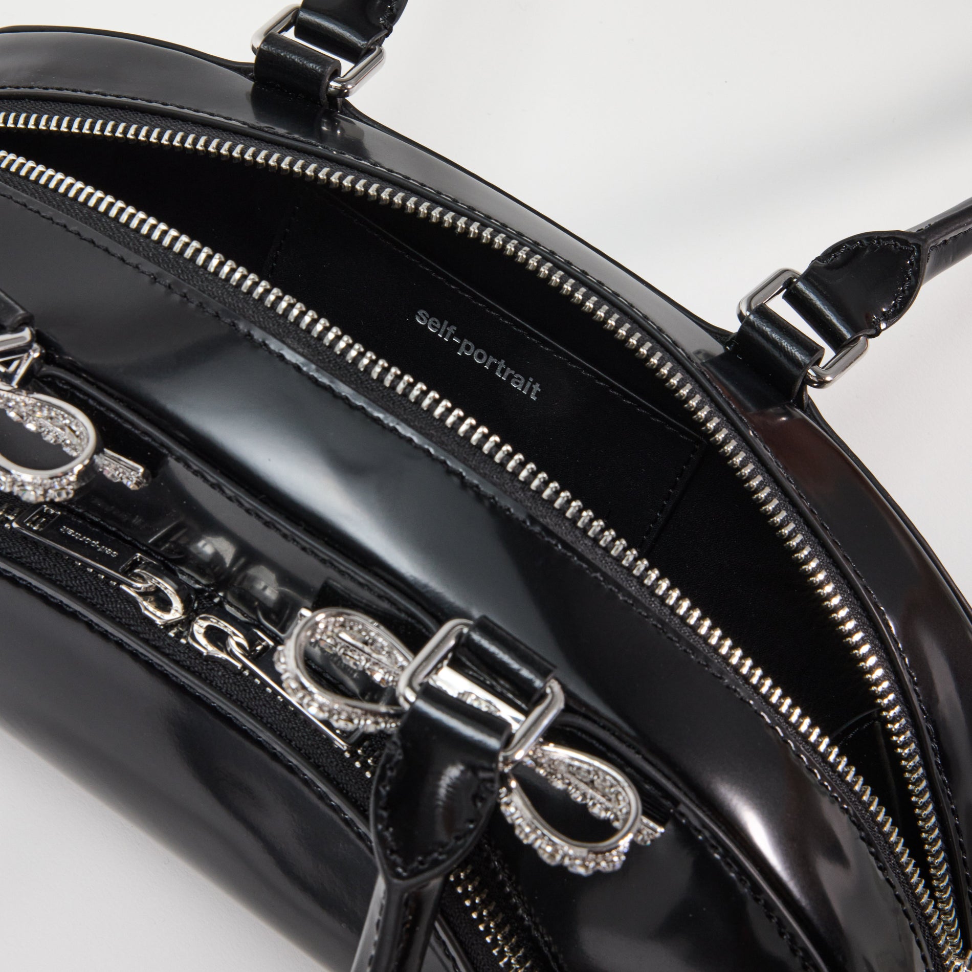 A close up of a woman wearing the Black Leather Curved Shoulder Bag