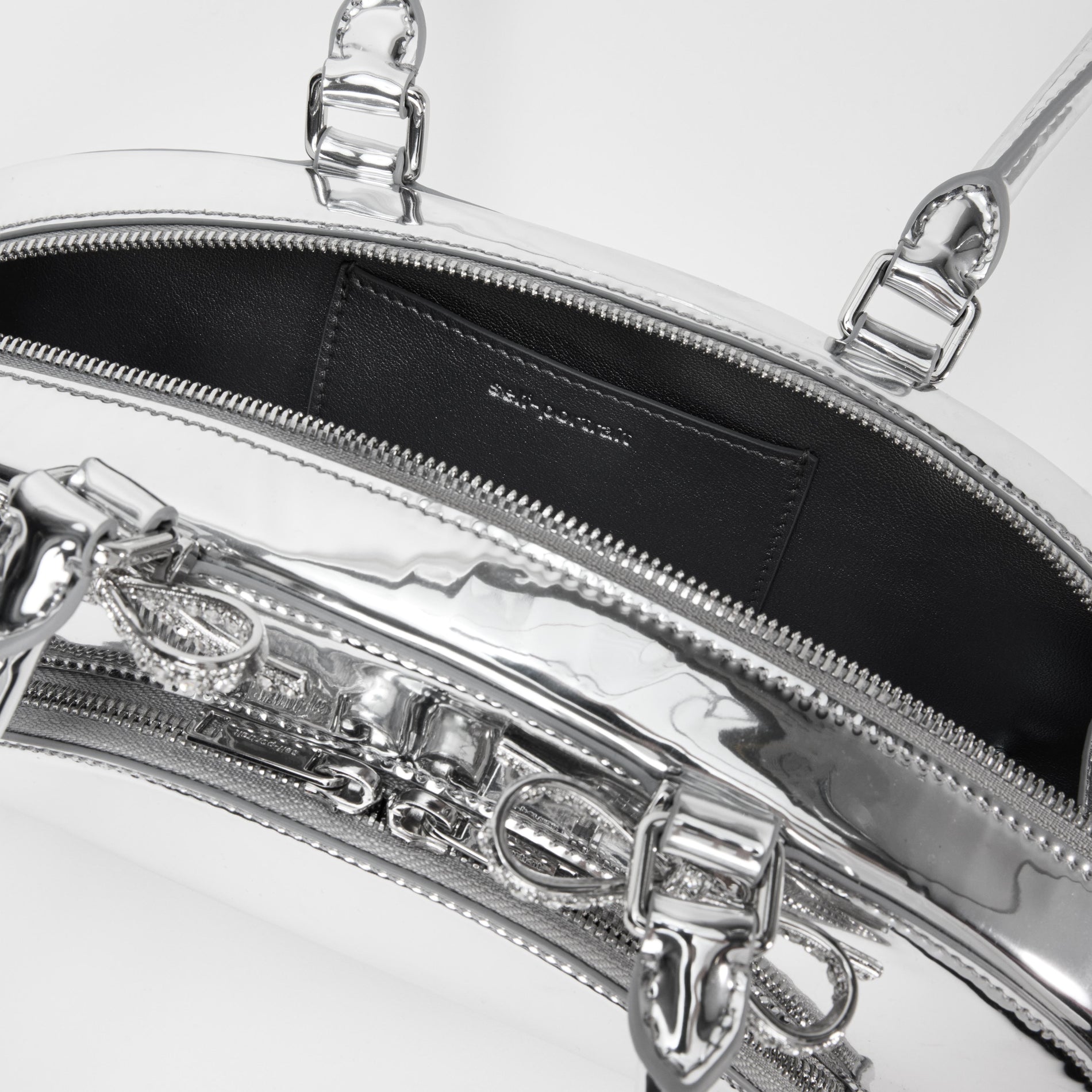 A close up of a woman wearing the Silver Metallic Curved Shoulder Bag