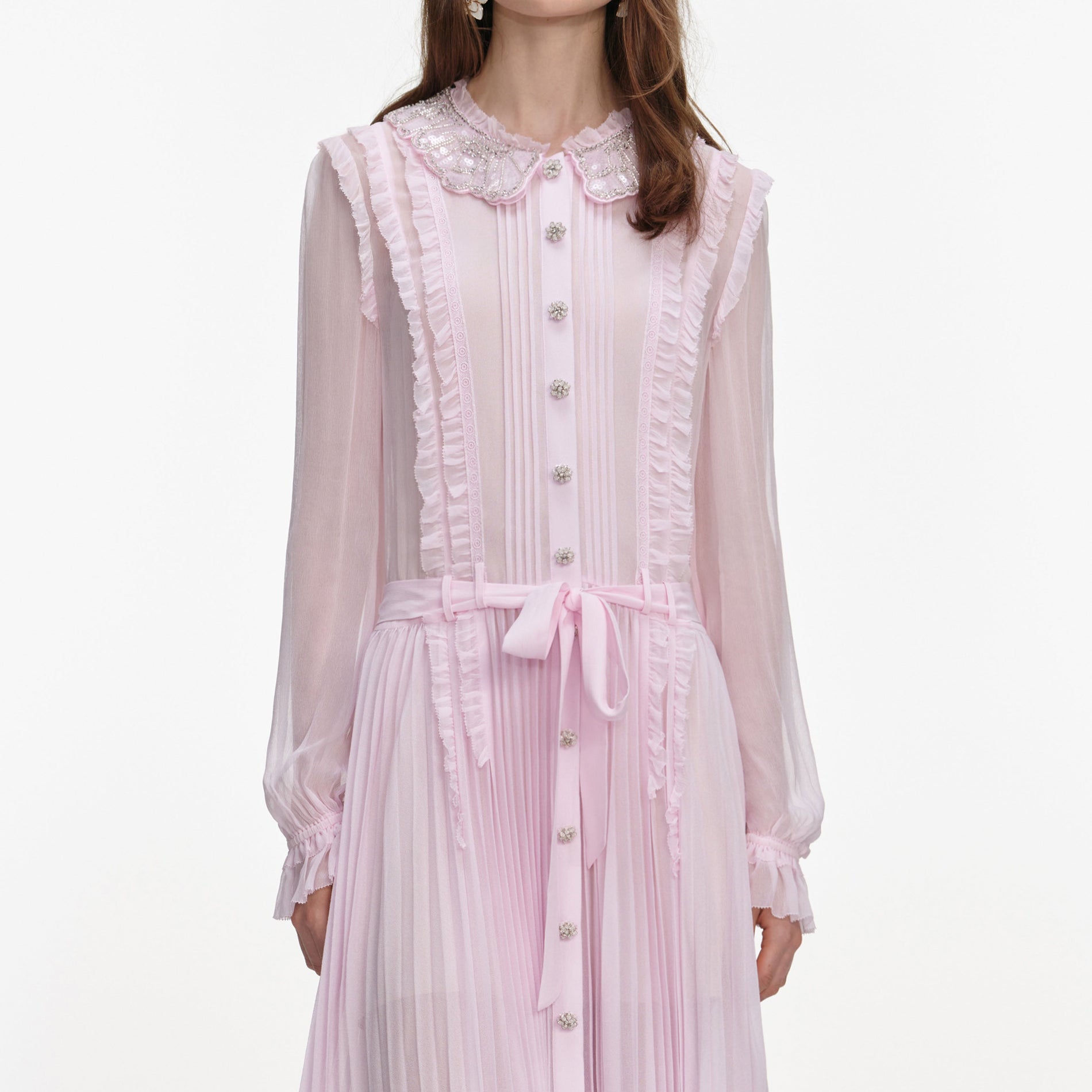 A close up of a woman wearing the Pink Pleated Georgette Midi Dress