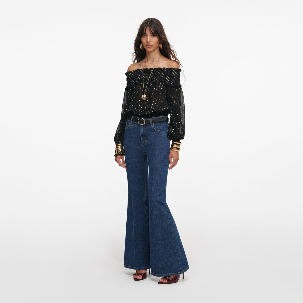 Side view of a woman wearing the Black And Gold Chiffon Top