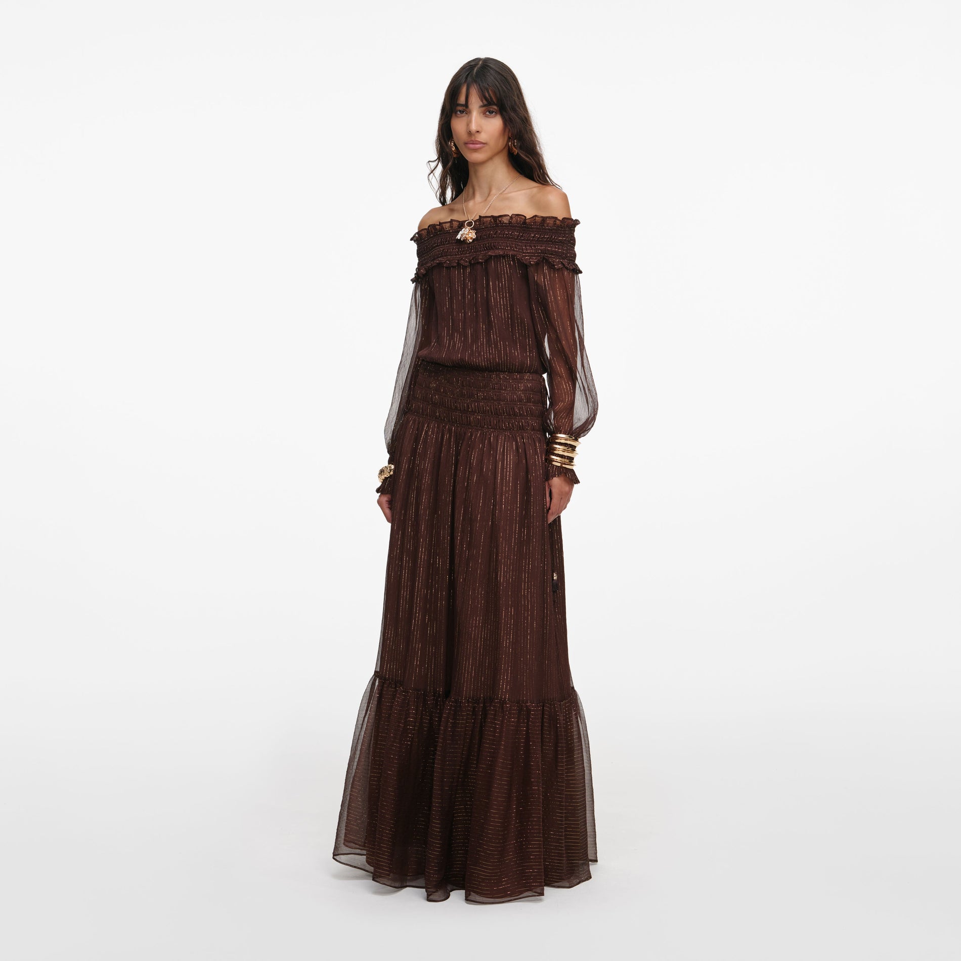 Side view of a woman wearing the Brown Georgette Off Shoulder Maxi Dress