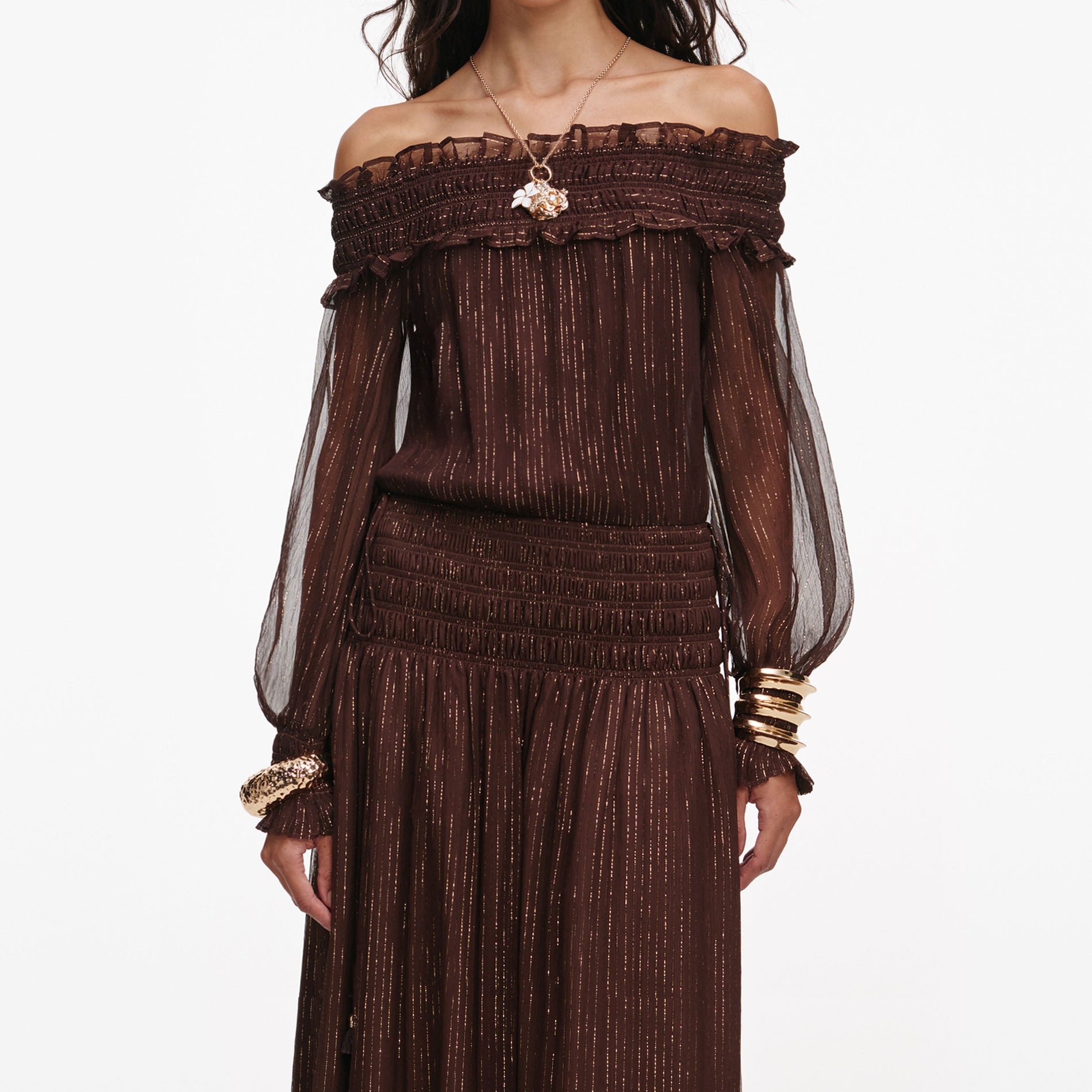 A close up of a woman wearing the Brown Georgette Off Shoulder Maxi Dress
