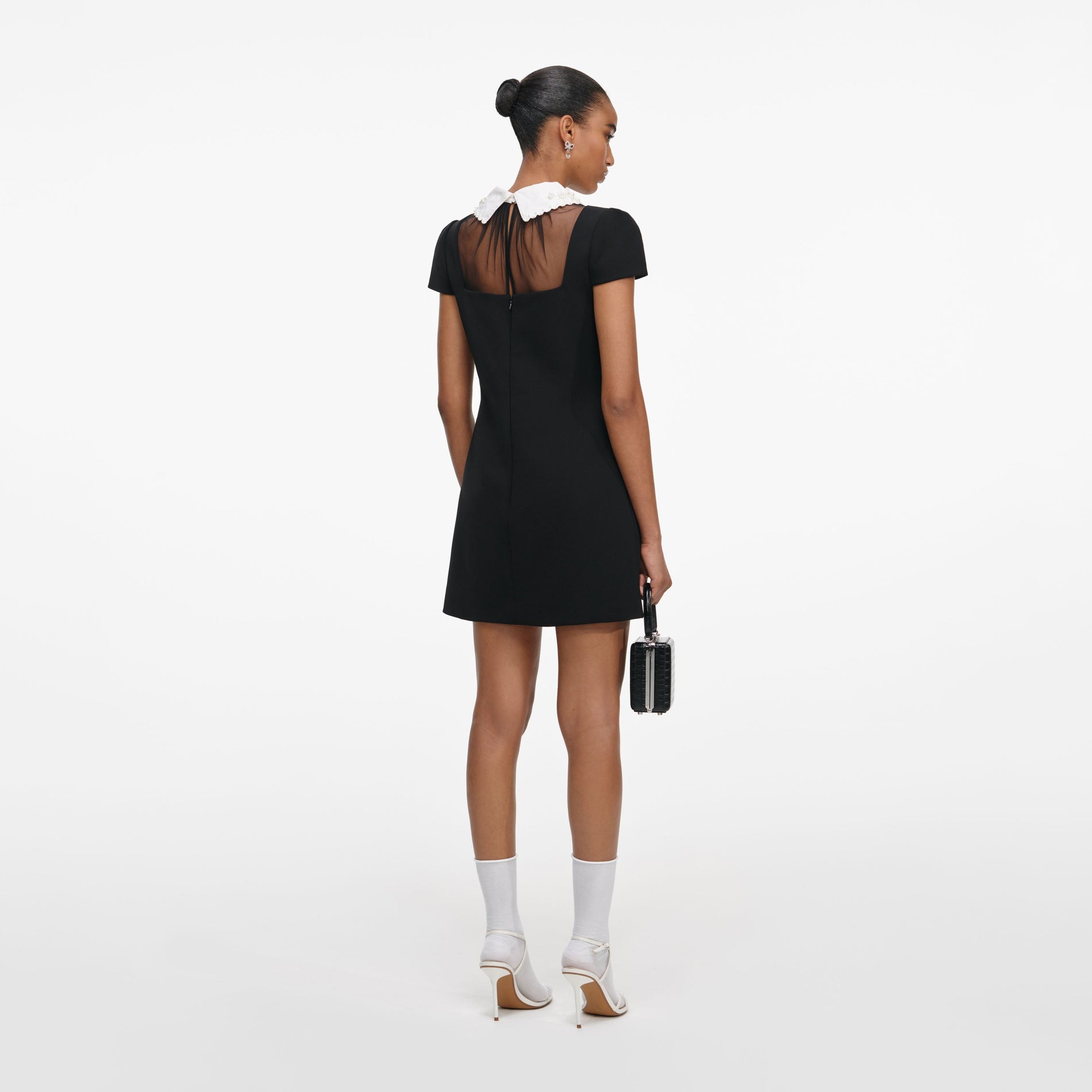 Back view of a woman wearing the Black Crepe Bow Collar Mini Dress