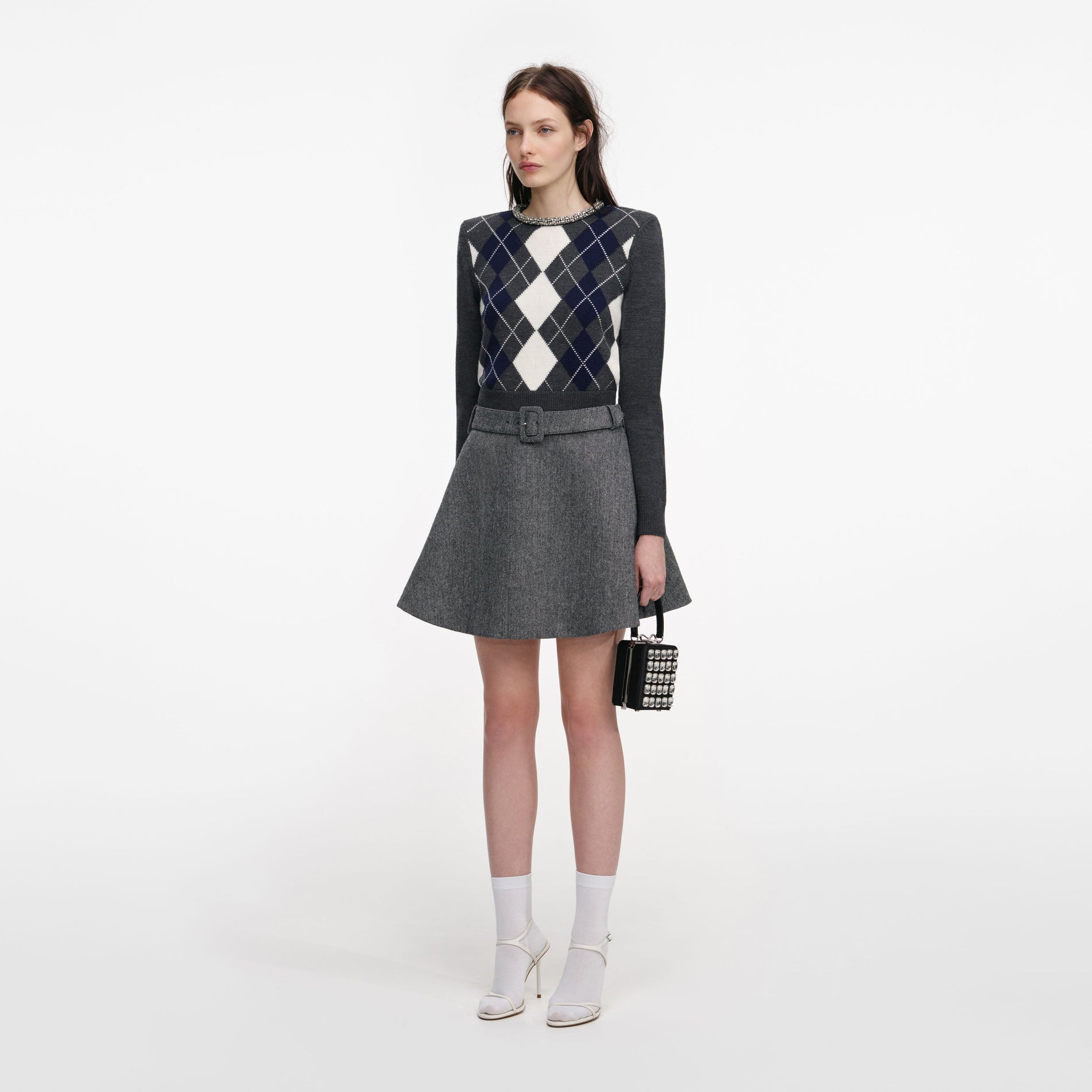 Side view of a woman wearing the Grey Argyle Crystal Trim Jumper